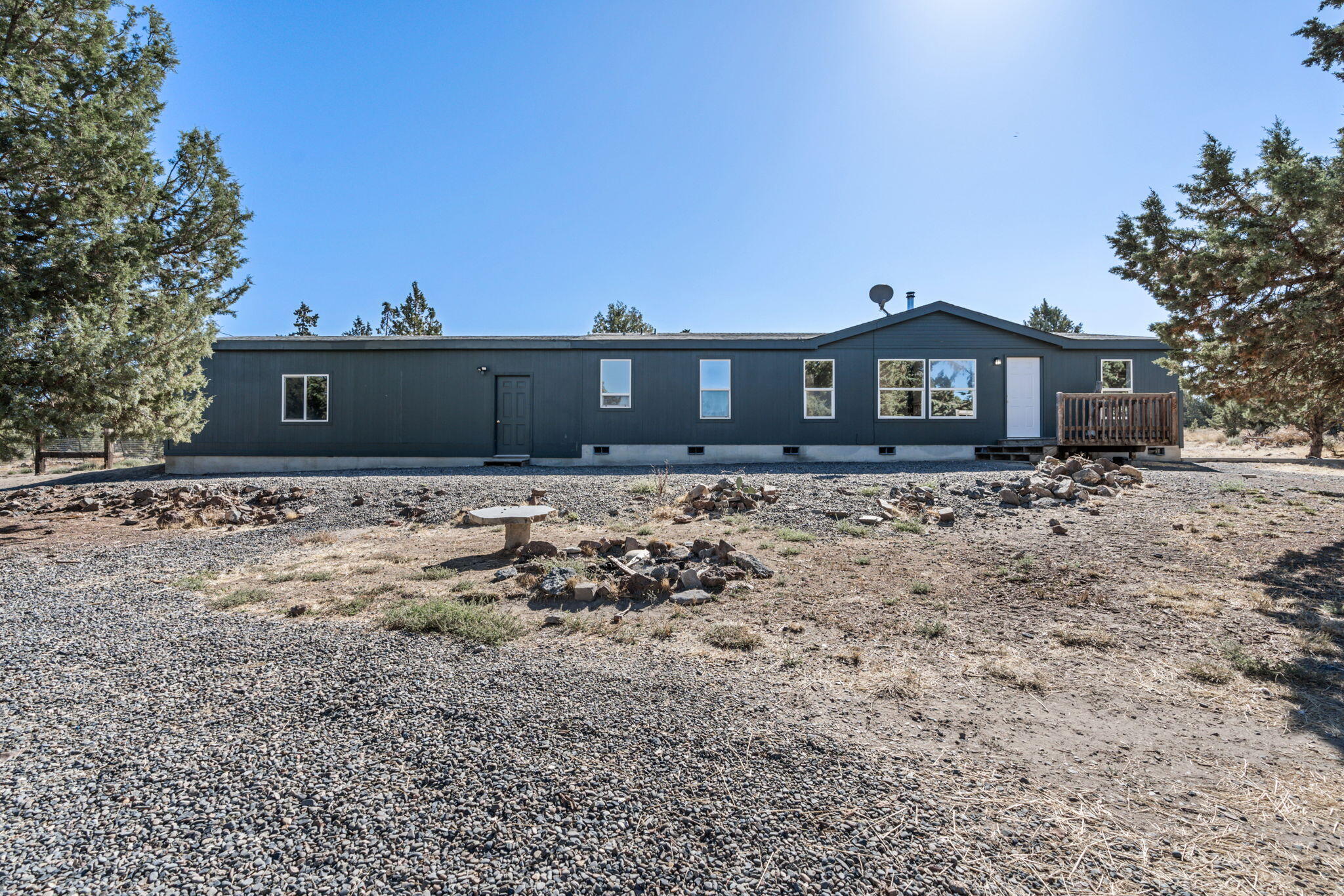 Don't miss this thoughtfully updated home on a private corner lot w/2.1 acres of partially fenced property!  Open floorplan features an abundance of natural light & updates throughout including flooring & paint. Main living area has a cozy wood burning stove & large windows. Kitchen is spacious w/plenty of cabinetry & counter space + a breakfast nook & separate dining area that could also serve as a small office space!  Well sized primary bedroom features vaulted ceiling, bathroom w/dual vanities, soaking tub & step in shower. Two additional bedrooms share a full bath as well. Storage room off laundry area, attached two car garage, storage building, concrete patio, private well, & plenty of space for all your toys & critters!