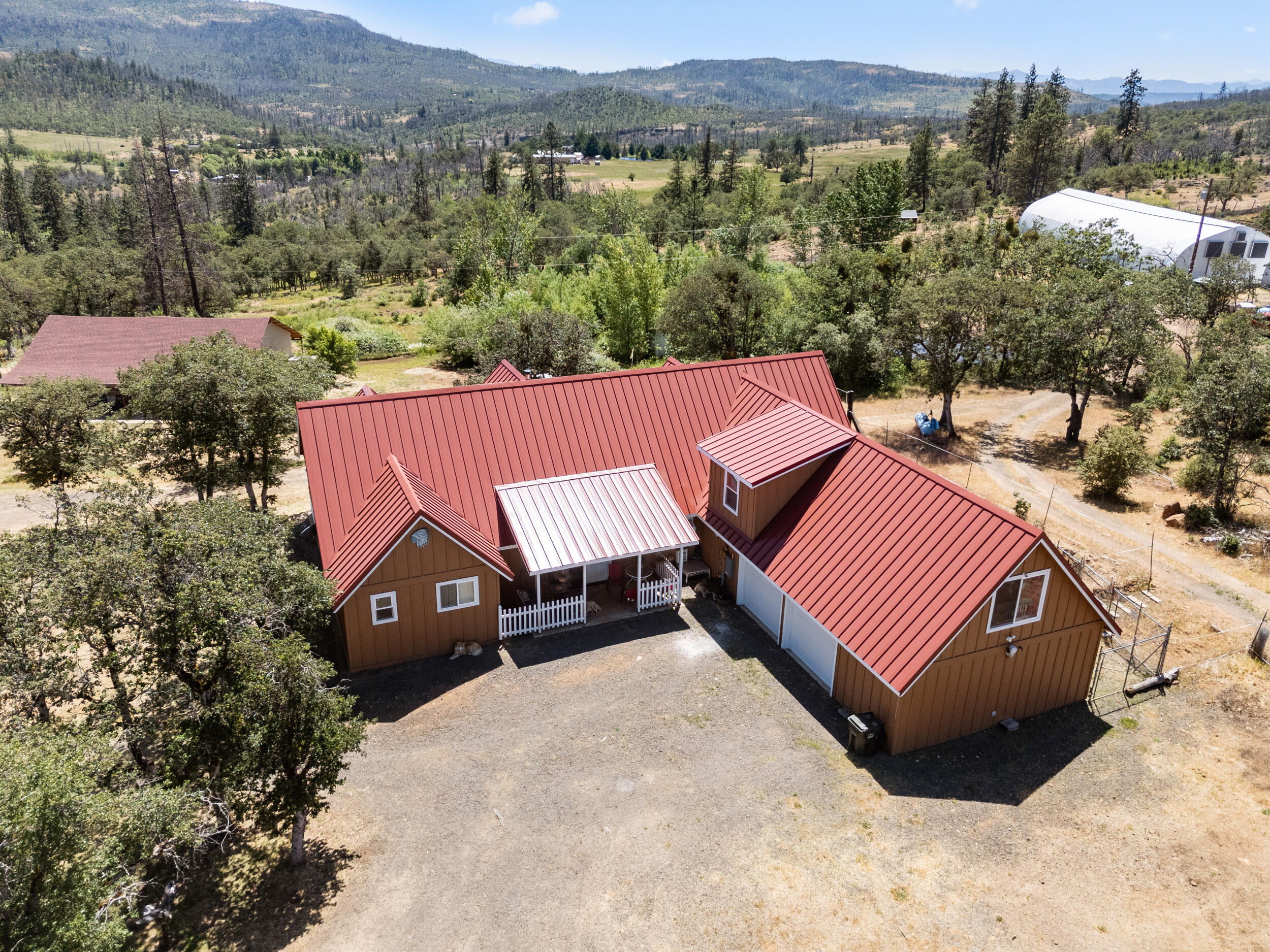 Custom built home + top tier farm perched on nearly 20 acres with 360 degree mountain VIEWS! This 3797 sqft home has 5 bedrooms, 3.5 bathrooms, 2 balconies, large deck with french doors from the master, living space & dining room. Primary bedroom features his/hers closets, walk-in shower, soaking tub. 2 staircases for easy access, wood burning fireplace, mud room & oversized laundry room. The attached 2 car garage & workshop are 732 sq ft of finished space with heating & cooling. Just below the home sits a new livestock barn. The farm is home to the highly successful Grass Roots Nursery, offering a turn key assumable active producer & processor licenses with no violations. Crops planted for Fall harvest, farm offers two huge ponds for all your water needs, a top of line greenhouse with computerized shades, massive air circulation system plus too many other features to mention. Also included is a second greenhouse, dozens of raised beds, processing room and security system.
