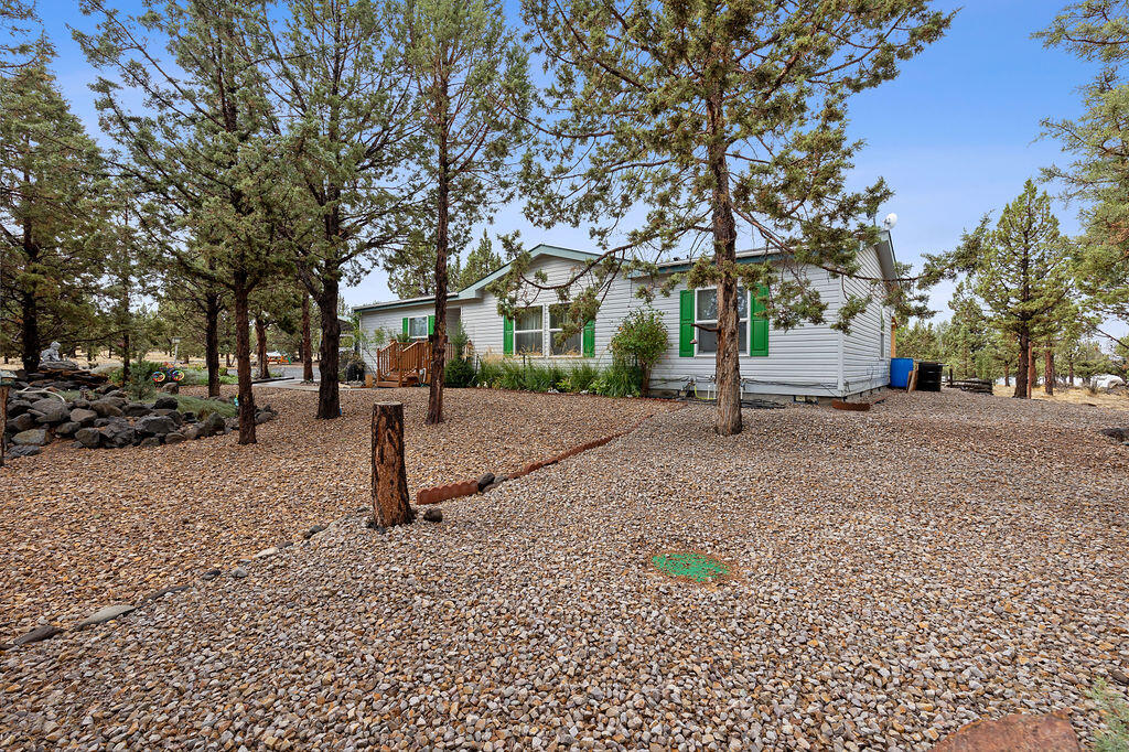 Well cared for 3 bed, 2 bath home with 1512 sqft, on two and a half acres. Laminate flooring throughout. Stone countertops in the kitchen which has an island. All appliances stay with the home. There is a fully fenced and gated deck off the dining room. Also, another lower deck with a hot tub which has a shade cover over it. The lot has trees for privacy, and low maintenance landscaping. All plants are on timed watering system. There is a fenced-in garden with raised beds, also on the same timed watering system for ease of care. A double shed for storage. The garage is 30x30 with two 10' roll up doors. Good sized attic storage above. Next to that is a metal RV cover 30' long x 22' wide. Fully fenced with a double front gate that can be closed.