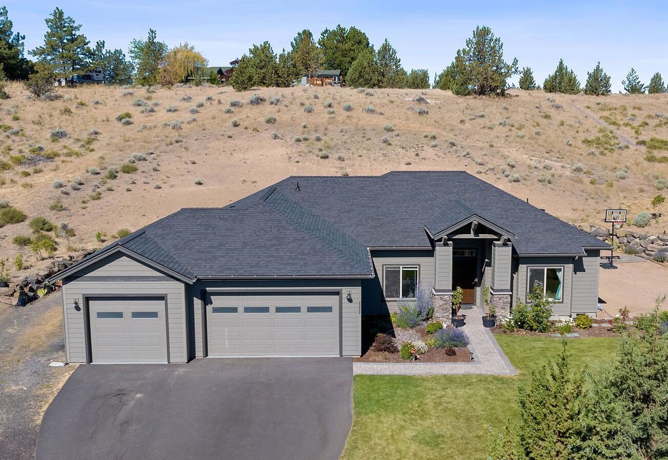 Enjoy the sunrises from this beautiful quality built home on two acres in highly sought after Bitterbrush Estates. Grand entrance into the large open living room with vaulted ceilings, propane fireplace and rock hearth. Enjoy the solid wood cabinets in this abundant kitchen with seating at the center island or dining room.  With three bedrooms and a den the space is abundant and the options are many. The back patio is private and could be your evening oasis or a great place to entertain. Room to park your RV and 30amp hookup included.  Builder upgrades included 5/8'' sheetrock, R45 insulation and insulated interior plumbing walls. Schedule your showing today to see all this home and space have to offer.