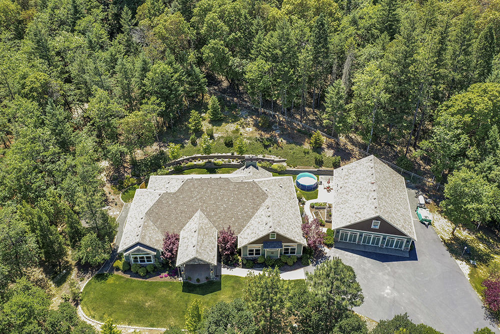 Stunning Pacific Northwest Custom.........first time on the market this 2011 custom beauty features 3 bedroom, 3.5 baths and over 3900 square feet on a single level.  Located in a private neighborhood with 5 other custom properties this one sets itself apart with the treed backdrop and dramatic setting.  Immaculate inside and out you are first impressed by the welcoming covered entry. Fabulous cooks kitchen with walk in pantry. Gorgeous office with custom built ins. Lots of tile, hardwood, granite and soaring ceilings throughout.  Split floor plan with a huge master suite and spa like bathroom. Custom cabinetry and two walk in closets.  Extra bedrooms share a full bath. Utility room is oversized.  Detached 3 car garage with extra big man size shop with 1/2 bath; above is hobby room and storage. Raised beds, gardens and professionally landscaped...this property does not disappoint!