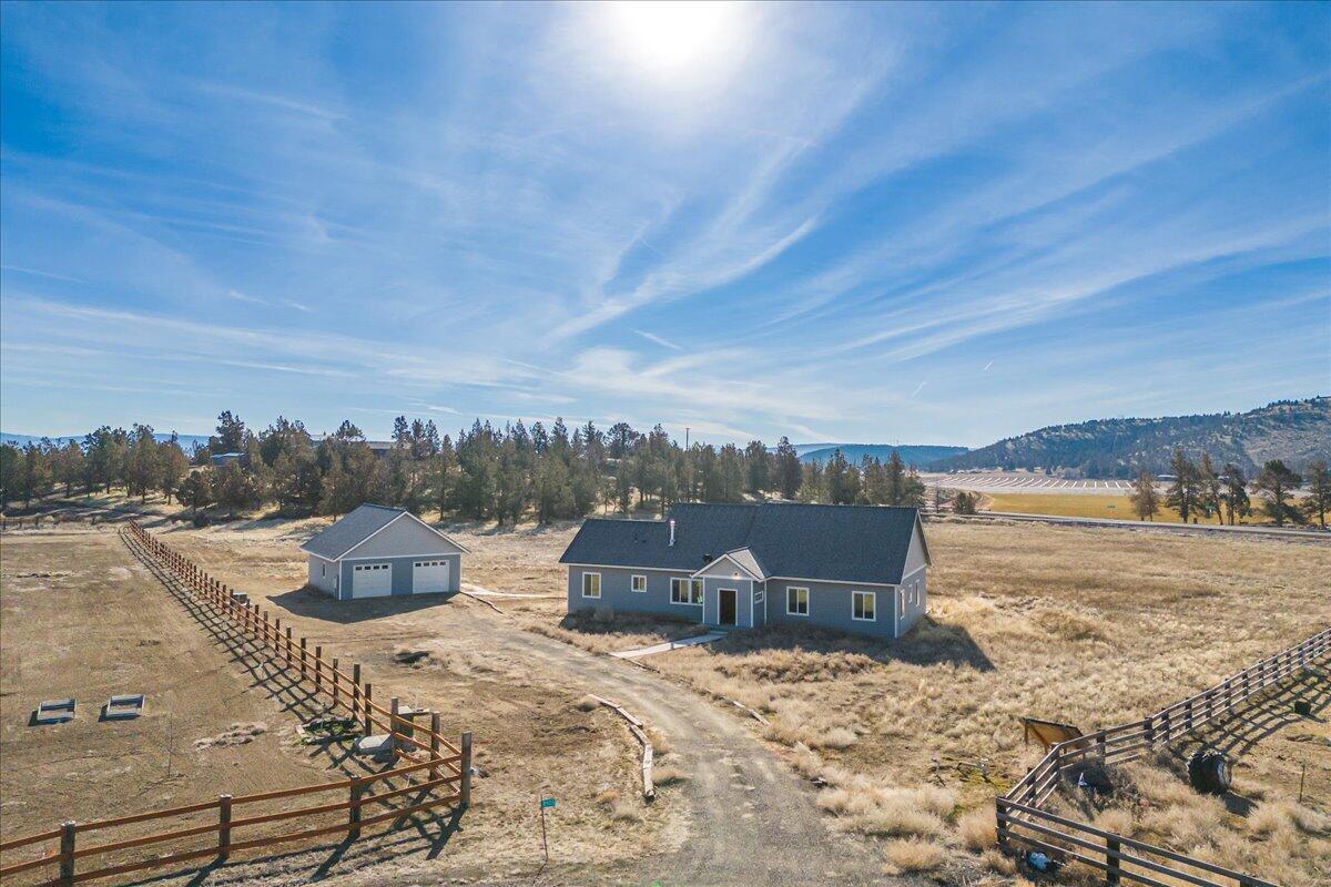 Originally designed and built as a fully off-grid property, this home is now connected to the grid to ensure consistent access to electricity while allowing for minimal electric bills. Located right off Highway 26, this 5-acre property near Prineville offers convenient access while maintaining a quiet atmosphere inside the home. Nestled within a peaceful HOA neighborhood of just 10 homes, it provides privacy and a close-knit community feel. The property includes access to 4.4 acres of irrigation through the Ochoco Irrigation District—simply install the irrigation equipment to utilize those water rights. Inside, enjoy a light-filled, remodeled interior featuring a spacious open kitchen with new appliances, wine fridge, and under-cabinet lighting. An expansive family room, 3 bedrooms, and 2.5 baths offer comfort and convenience. Deck footings are in place and ready for your custom outdoor space. A detached oversized two-car garage and dedicated solar panel shed complete the property.