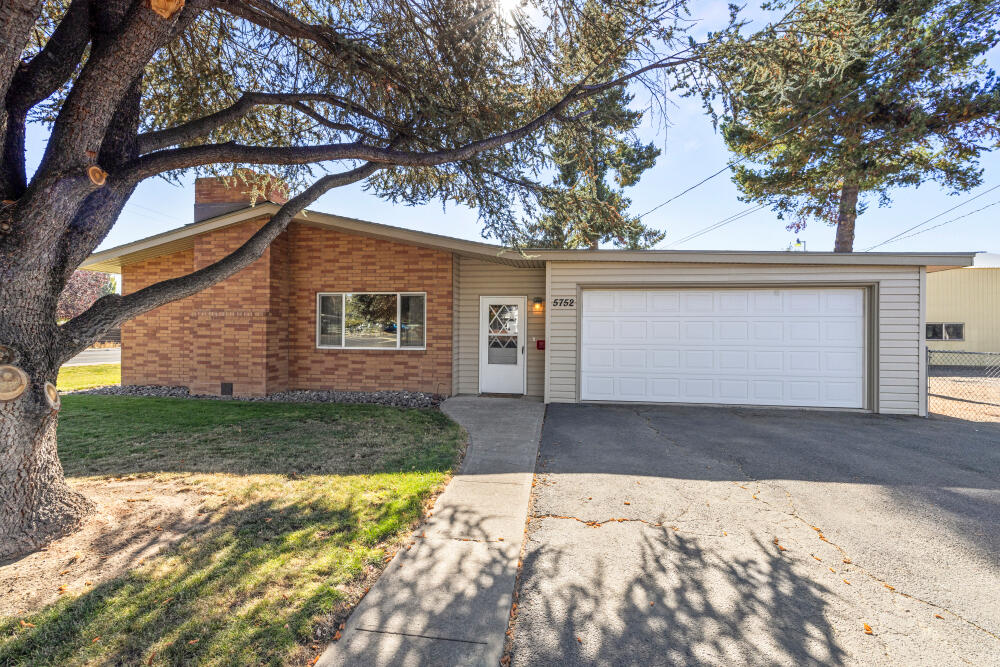 Large Shop and a solid 4-bedroom, 2-bath home offering comfort and versatility. Features include wood flooring, vinyl windows, and a sunken living room with new carpet. Attached 2-car garage plus an industrial-sized detached 30'x40' shop with concrete floors, tall 14' roll-up door, bathroom (may need work), and separate driveway access—ideal for hobbies, storage, or business use. Fully fenced yard with Enterprise irrigation and abundant parking. Home shows in overall good condition with some dated finishes—great opportunity to own a property with a rare oversized shop in a desirable suburban neighborhood!