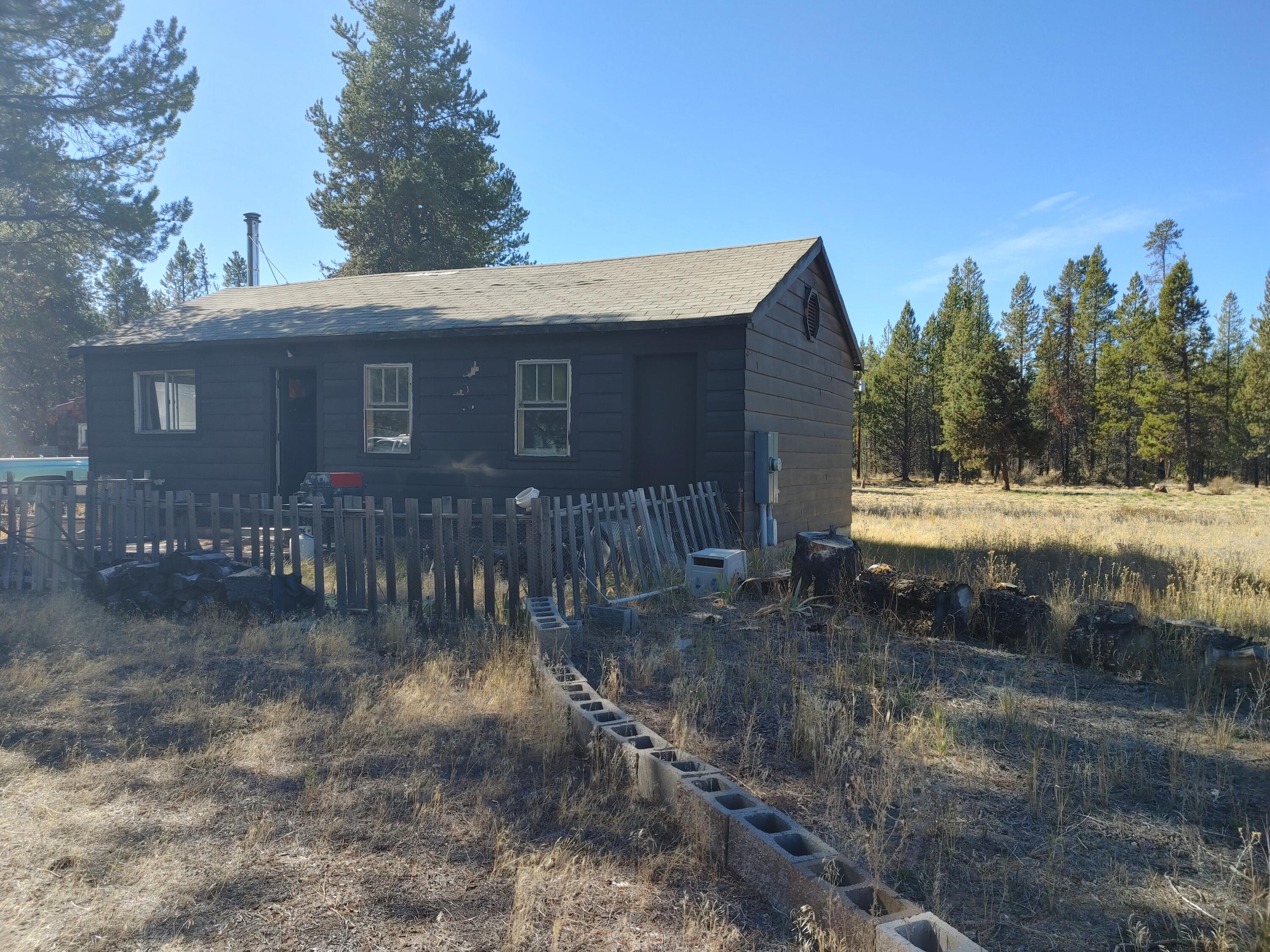 This little cabin has so much potential & Original Charm come and bring your touches to this cabin and bring back its Charm!!  This home is 1 bedroom 1 bath.  Home is in need of some TLC & new roof!  Would make a Great Cabin Get-Away or fishing Shack.   Sits on a corner lot in the area of being hooked up to city water & Sewer.  Has a detached shop area that is also in need of TLC and part of the roof has collapsed.  The well is not currently hooked up to the home and will need to be done by the buyer, possible broken pipes.   Home is being sold AS-IS condition only!! Owner is willing to Carry with a large down payment