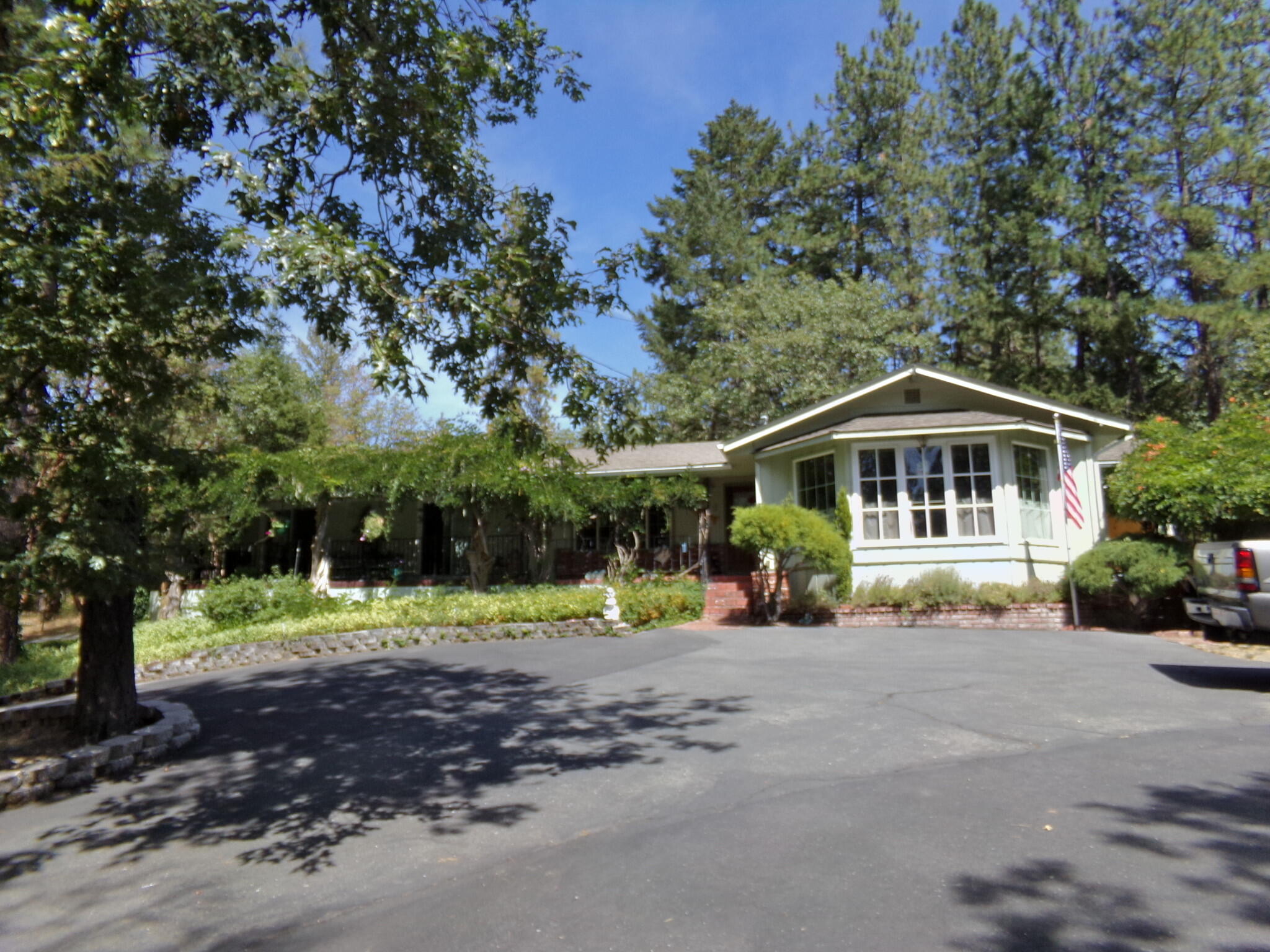 About a ½ mile from the Grants Pass Golf Course. This single level Cathedral Hills home is backed up to 400 acres of BLM land, the Cathedral Hills Trail System. Sided by seasonal creek, the home has been updated with custom cabinets, granite counter tops & tile floors. Dining area, breakfast bar, woodburning fireplace with rock mantle. The attached garage was converted into a den/bar area, adding 400+sqft living area. It has a primary bed & bath, and two other bedrooms with extra deep closest. The sliding glass doors led to the huge covered rear deck lit by an elkhorn chandelier; the deer are friendly. Garden/landscape line the rear of the house and ramp access. The 4 car garage has private toilet/sink, and outdoor shower for when you're using the hot tub. The area above the garage is perfect for guests, equipped with deck, bedroom, bathroom with shower, fridge and ductless heat/cooling.