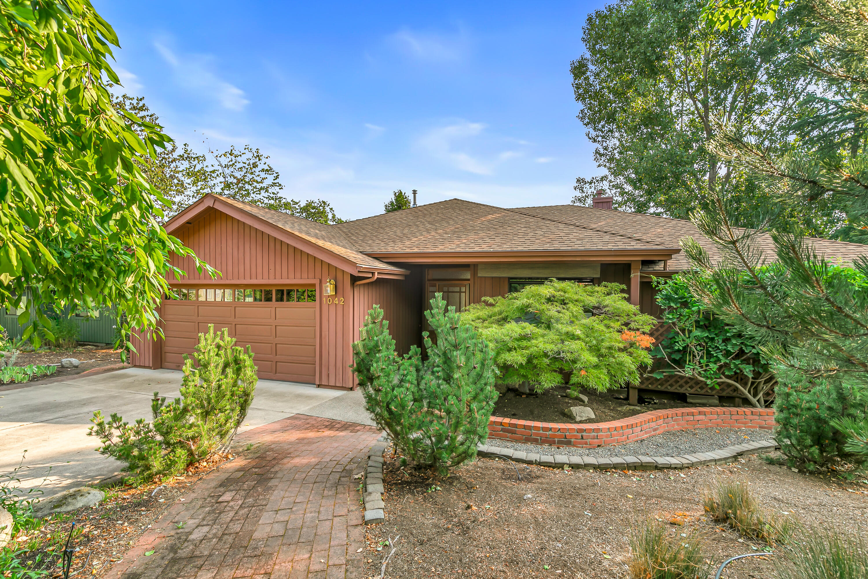 Oak Knoll neighborhood with privacy & plenty of open space. Entering the Living room, you are greeted with mountain views & natural sunlight provided by vaulted ceiling, skylights & large windows. Maple flooring & a gas fireplace for those chilly fall & winter days. Main level provides you with a large primary bedroom, spacious dual vanity bathroom, two guest bedrooms, a large kitchen with separate eating area or additional dining area. Enjoy a covered main level patio for entertaining friends or relaxing with your favorite book. Downstairs has 1300 sq ft of fully furnished spacious living with an additional primary guest suite, Livingroom, jacuzzi tub, wet bar, radiant flooring & a walk-out patio for family or guests to enjoy. Opportunity for workshop or large storage area. Super-efficient heat pump, on-demand tankless hot water heater for more energy savings. Close to YMCA, shopping & golf course.