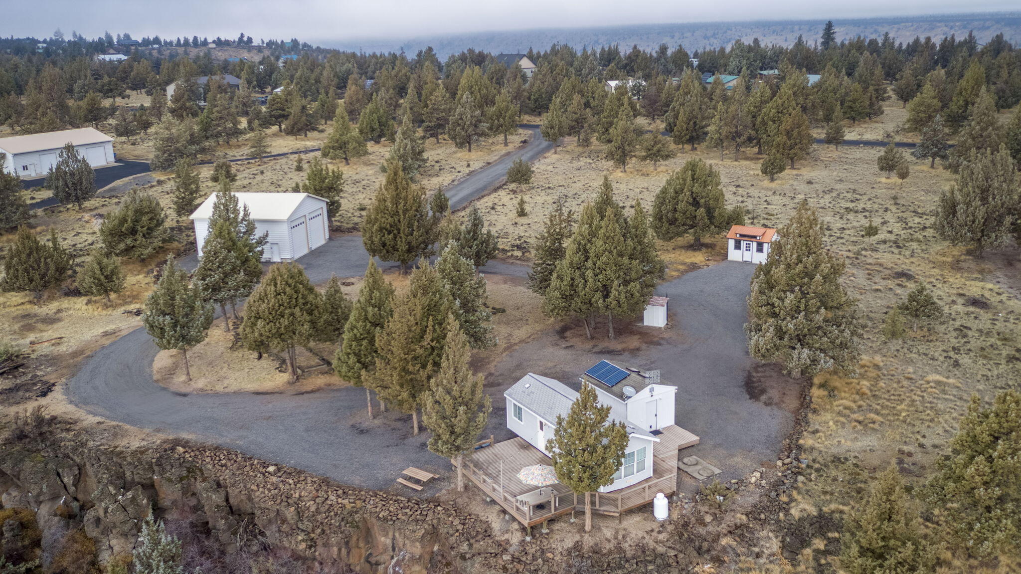 Discover your off-grid escape in the Three Rivers Landowners Association, featuring incredible private access to Lake Billy Chinook and endless recreation. This 5.1-acre rim lot delivers sweeping, panoramic views of the Cascade Mountains, Culver city lights, Smith Rock. Property is fully set up for immediate enjoyment and future possibilities. A 32x36 stem-wall shop offers concrete floors and two 14-ft roll-up doors—ideal for boat storage, toys, or projects. The clean park model with a TREX deck provides comfortable living space, complemented by a guest friendly bathhouse and  a recently added shed currently used as a cozy bunkhouse. Systems are in place and ready: septic holding tank, solar with inverter , generator and four new batteries. A gravel driveway provides easy access and plenty of space for  extra parking. This property also gives buyers the opportunity to enjoy it now while planning a future home or cabin if they desired.
