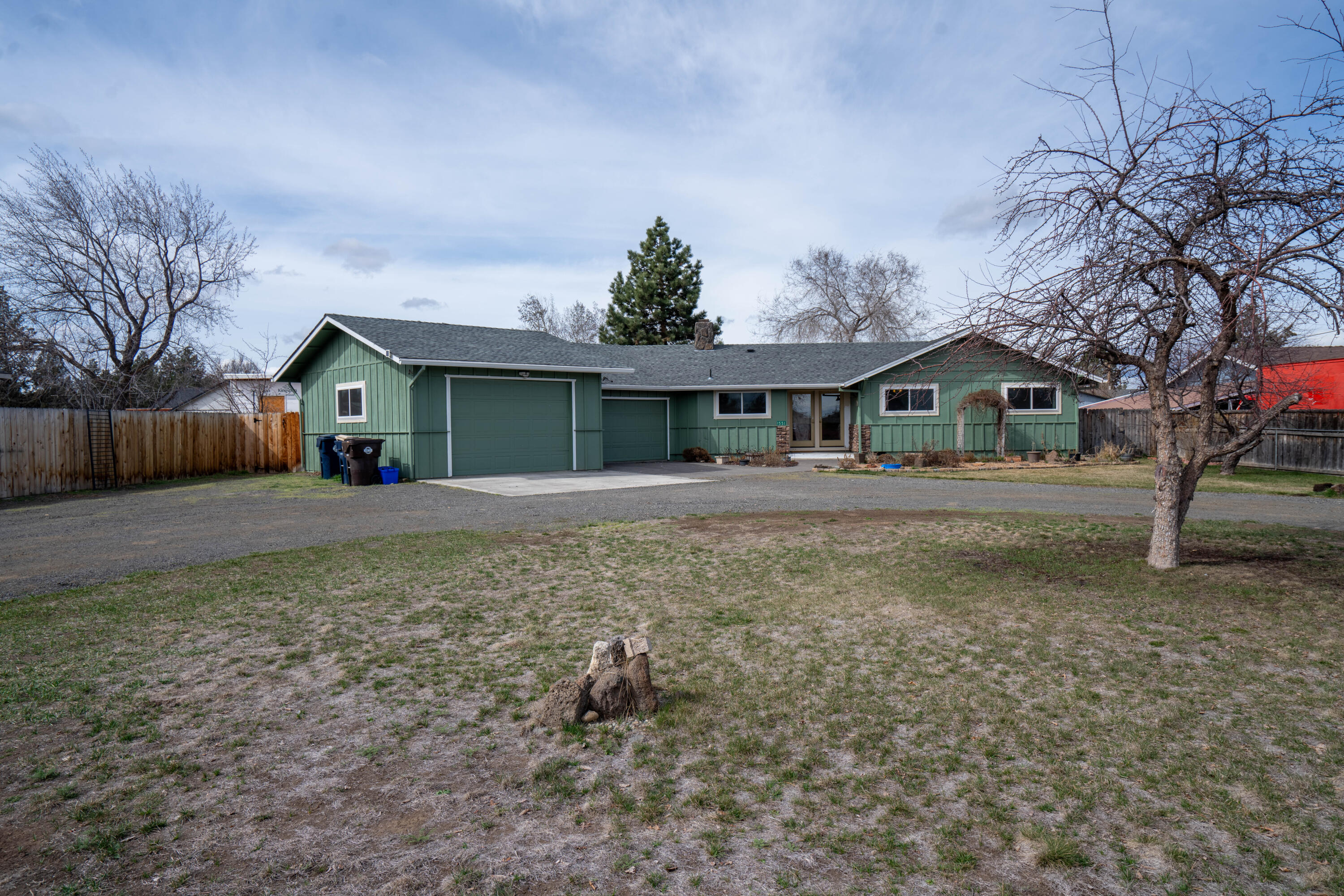 Must see single-story home on huge .39-acre lot with plenty of room for RV + toy parking! This stick-built home has a beautifully updated kitchen with granite counters, a backsplash and stainless steel appliances including a gas cooktop. Hardwood floors in the kitchen, living area and office space, which also has slider doors for easy backyard access. Continuing, the main bathroom has been elegantly updated with a custom tile corner shower as well as tile counters. The gem of this property is the rare, attached triple-car garage with an oversized third bay that has a workshop area plus two man doors for accessibility. The large backyard outdoor space is fenced and consists of a paver patio, mature trees and luscious landscaping. In the front of the home, discover ample front yard space as well as a circle driveway. Home is well-situated, sitting off the road. Solar panels work apx $49 a month for power