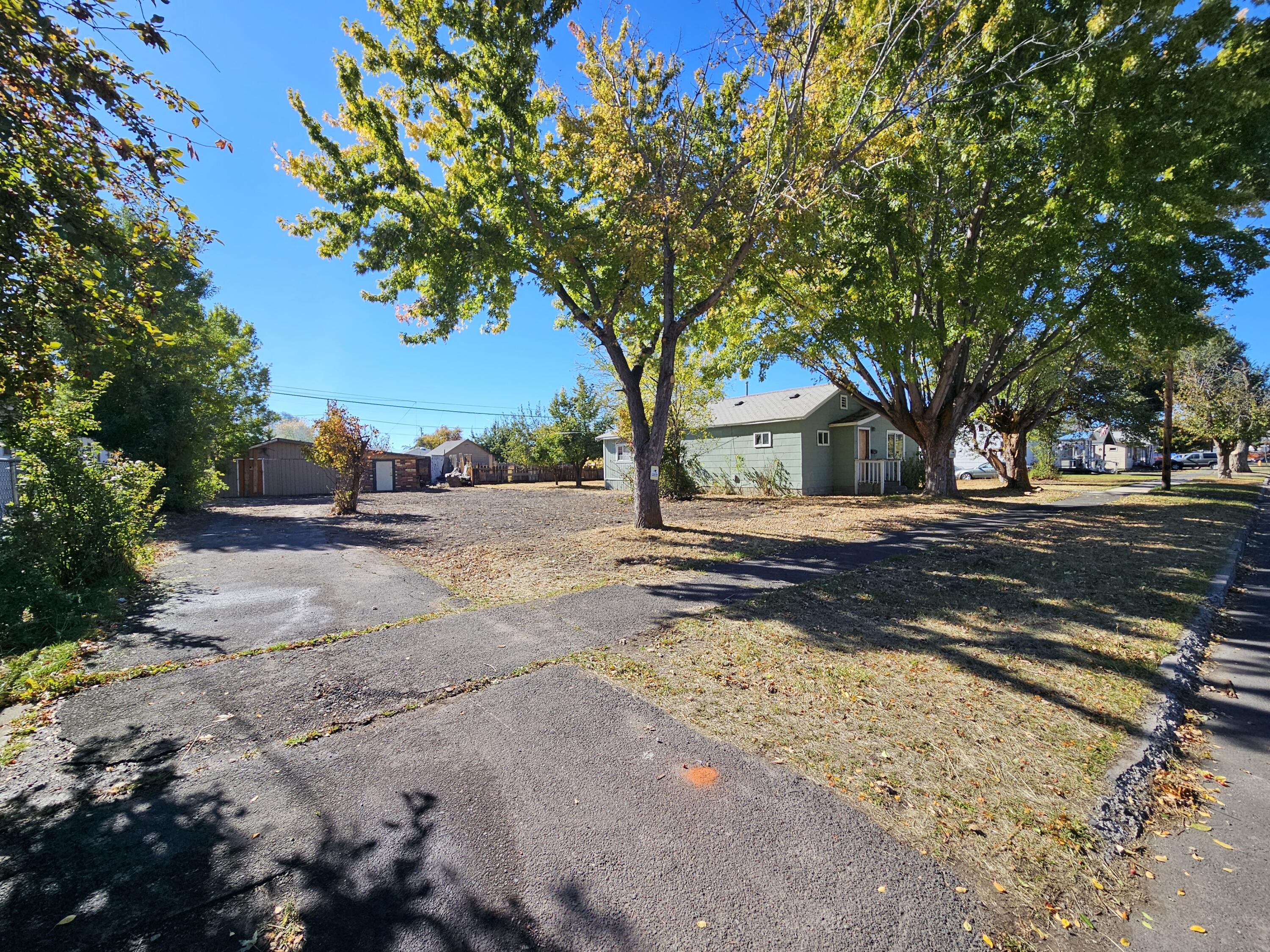 Level residential lot, ready for development! Paved driveway to large shop with cement floors (744 sq.ft. per Assessor). Alley behind. Located convenient to downtown. Suitable for frame or manufactured home development, or, utilize as-is! Per the city, massive grants offered toward development SDCs for this property- inquire for details. Buyer to do due diligence on all property details, lot uses, and development potential.