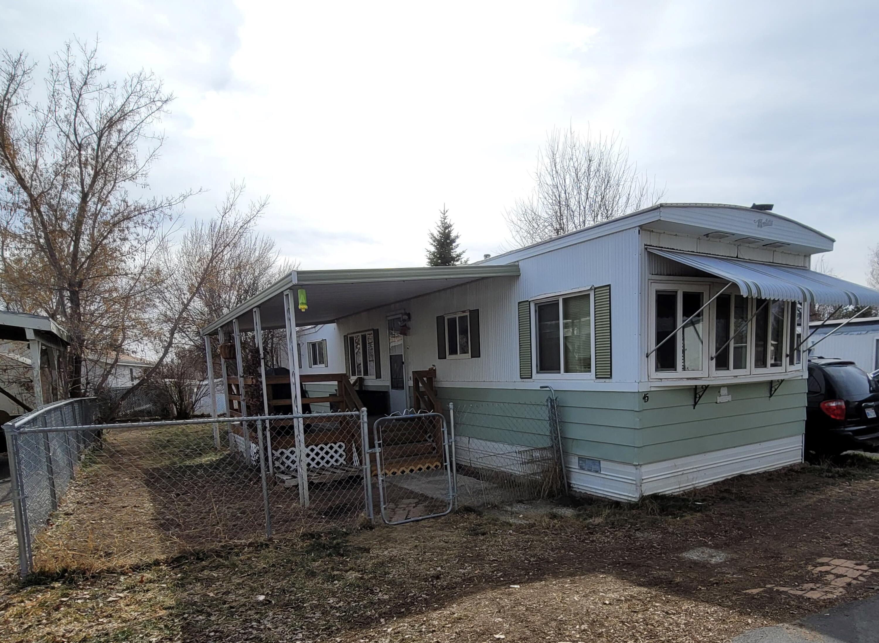 Clean and cute and ready to be yours! This 2 bed 1 bath home is in great shape for its age. There is a nice chain link fence that goes all the way around the home. Comfortable, covered deck off the front and a carport with a shed in the back. Located in Madison Village.
