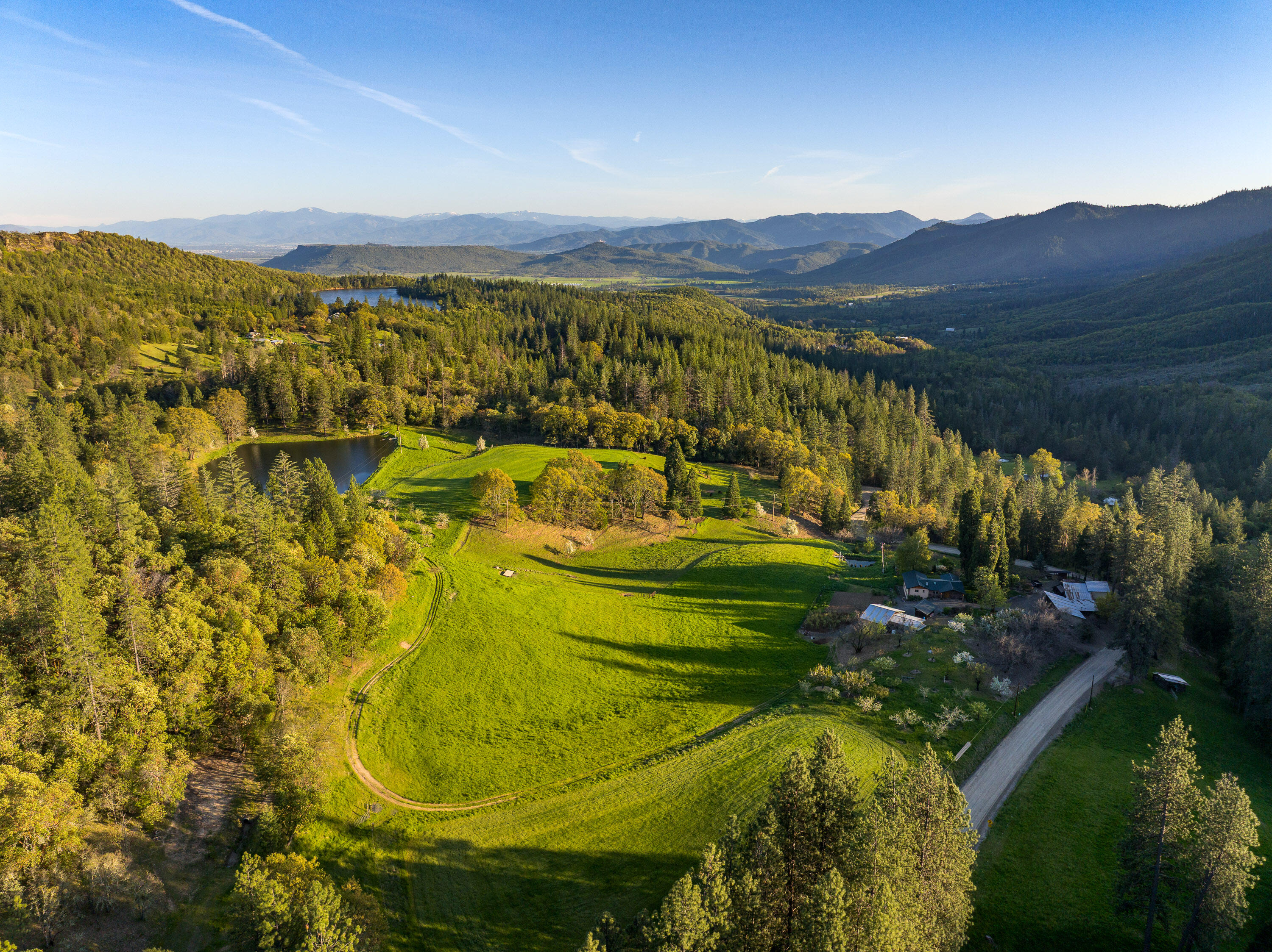Situated at approximately 2,000 feet in elevation, this ranch enjoys a peaceful setting above the valley floor, providing stunning views and a sense of privacy that is increasingly hard to find.  Spanning 127 acres, the property features livewater, rolling pastures, forests, and direct access to public lands. Water features include Price Reservoir, two creeks, and additional ponds. Timber inventory is estimated at 1.39 million board feet with a net value of over $400,000. The well-maintained home features an open-concept floor plan, updated kitchen, expansive views, and great indoor/outdoor living. Outbuildings include a versatile farm building with a licensed kitchen and walk-in cooler, barns, plus many more improvements. Operated as a niche market farm, the property has established orchards, gardens, and pastures. Recreational opportunities abound with hunting, fishing, hiking, & horseback riding on site and nearby. Located +/- 20 miles from Medford & the Rogue Valley Int' Airport.