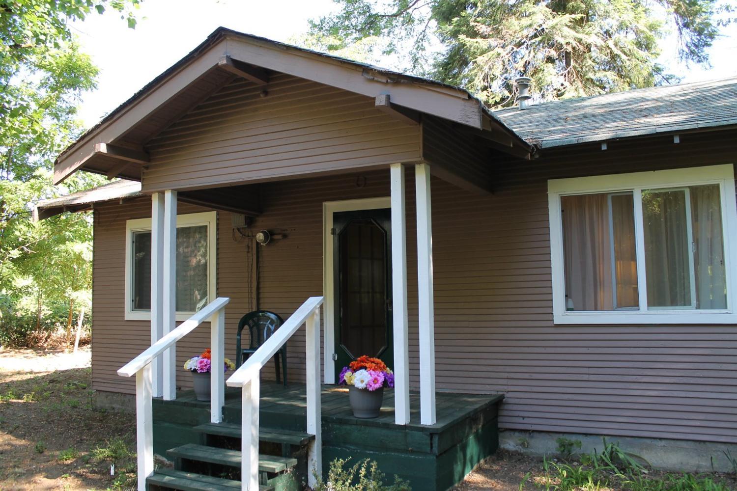 Level 1.18 acres in Grants Pass, with GPID. This charming home was built in 1929, and features 2 bedrooms, 1 bathroom, and is approximately 900 sq feet. The home is full of character, and even has the original front door and hardware. Cared for over the years, there have been updates to the home. Sheetrock, paint, flooring, some windows, and some fixtures. There are 2 outbuildings towards rear of the property, one is about 28 X 12, and the other is about 6 X 8. Could be used for storage, canning, etc. Both could use some TLC. The large building out front near highway, is used for storage. Lots of potential off the rear of the home for. Level open area, to make it your own.