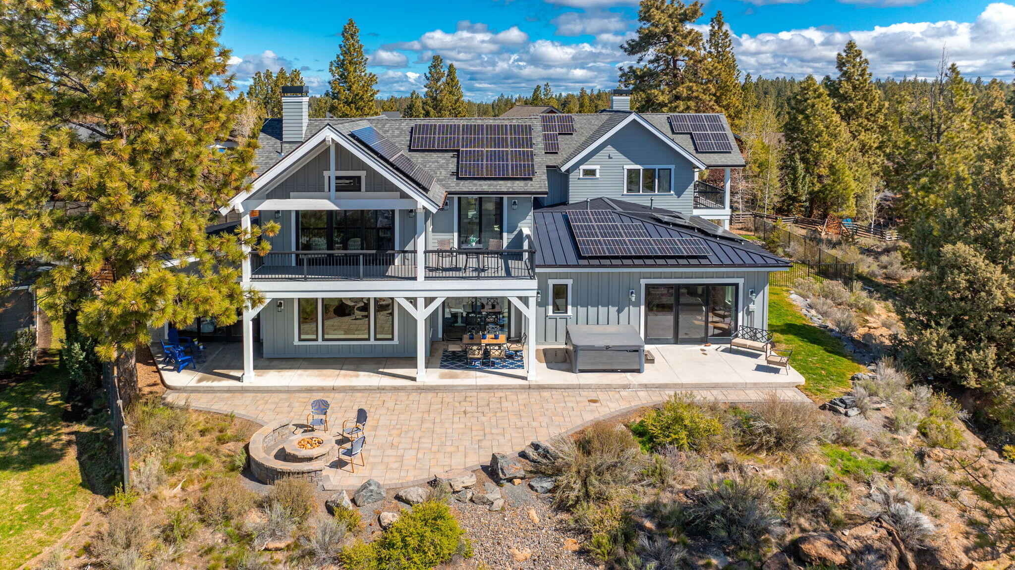 Experience luxury and seclusion in this custom-built home in Bend's coveted Northwest Crossing neighborhood. Set on a private, low maintenance .55-acre lot, this open-concept home boasts panoramic views of Discovery Park & the Paulina Mountains, visible from nearly every room and multiple outdoor living areas. The main home features 3 bdr & 3.5 bth, with dual primary suites on the main level, with direct outdoor patio access. A dedicated office/den on the main level, with built-in cabinets, provides a quiet workspace. Upstairs is a spacious bonus room w/ wet bar & 3rd ensuite bedroom. Additional amenities include an adorable studio ADU, atop a spacious, heated 2 car garage & 32 ft RV/Sprinter Van 3rd bay. Energy efficiency is paramount with an E2 13.76kW solar system & an Earth Advantage Platinum Certification. Located adjacent to park land, & just minutes from local shops, schools, & restaurants, this home blends sublime natural beauty and privacy with unmatched convenience.