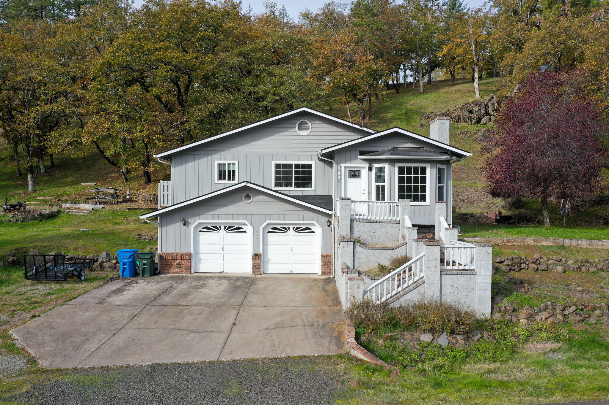 This well-maintained home sits in the hills of a desirable area of Shady Cove with wonderful views! For outdoor enthusiasts, you are just minutes away from the Rogue River where you can hike, fish and raft. Property offers 3 bedrooms, 2 full bathrooms, 1347 sq ft, 2 car garage and sits on 1.17 acres. Sit back and relax on the back deck which can be accessed from the kitchen or the primary suite. Home features a spacious living room with a wood burning fireplace, large window great for natural light and beautiful views, open kitchen with a cooktop island, stainless-steal appliances, eating area, enclosed laundry room and built in shelves. Access your garage by going downstairs just off the kitchen. Garage has plenty of room for 2 cars, storage and workspace. Property has lots of mature trees up the back side and has plenty of space to park recreational vehicles/toys and/or plant an upcoming garden. Lots of potential with this rural setting home!