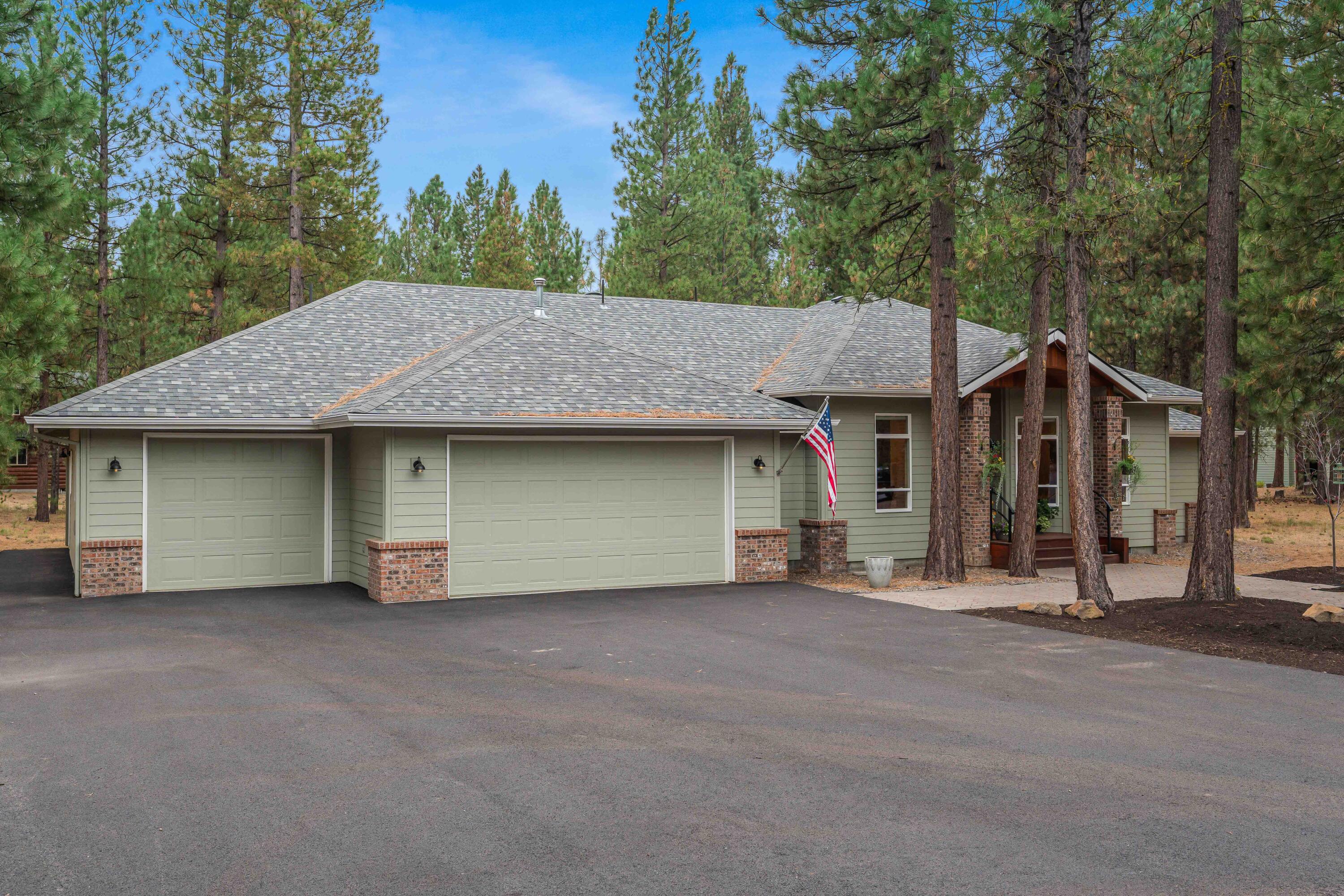 Quality living in La Pine's finest neighborhood - Wild River! This single level home on half an acre is a 5 minute walk to community trails and Deschutes River access, where residents can cast their fishing lines among the pines. Enjoy refined living surrounded by nature with a strong sense of community. Step inside to an open foyer and dedicated office with a stunning custom cedar floating desk. Circular flow connects kitchen, dining, and living room with a Lodi wood stove and sliders to an expansive deck. The chef's kitchen features a 6 burner gas cooktop, double ovens, granite counters, Dacor appliances, and coffee bar. The spacious primary suite features a tray ceiling, bay window, jetted tub, tiled shower, dual vanities, and walk-in closet, while two additional bedrooms share a full bath on the opposite wing. Recent updates include a 40 year roof and 2025 water heater. The 4 car garage provides abundant storage or workshop space. Potential to add a detached shop. A dream set up!