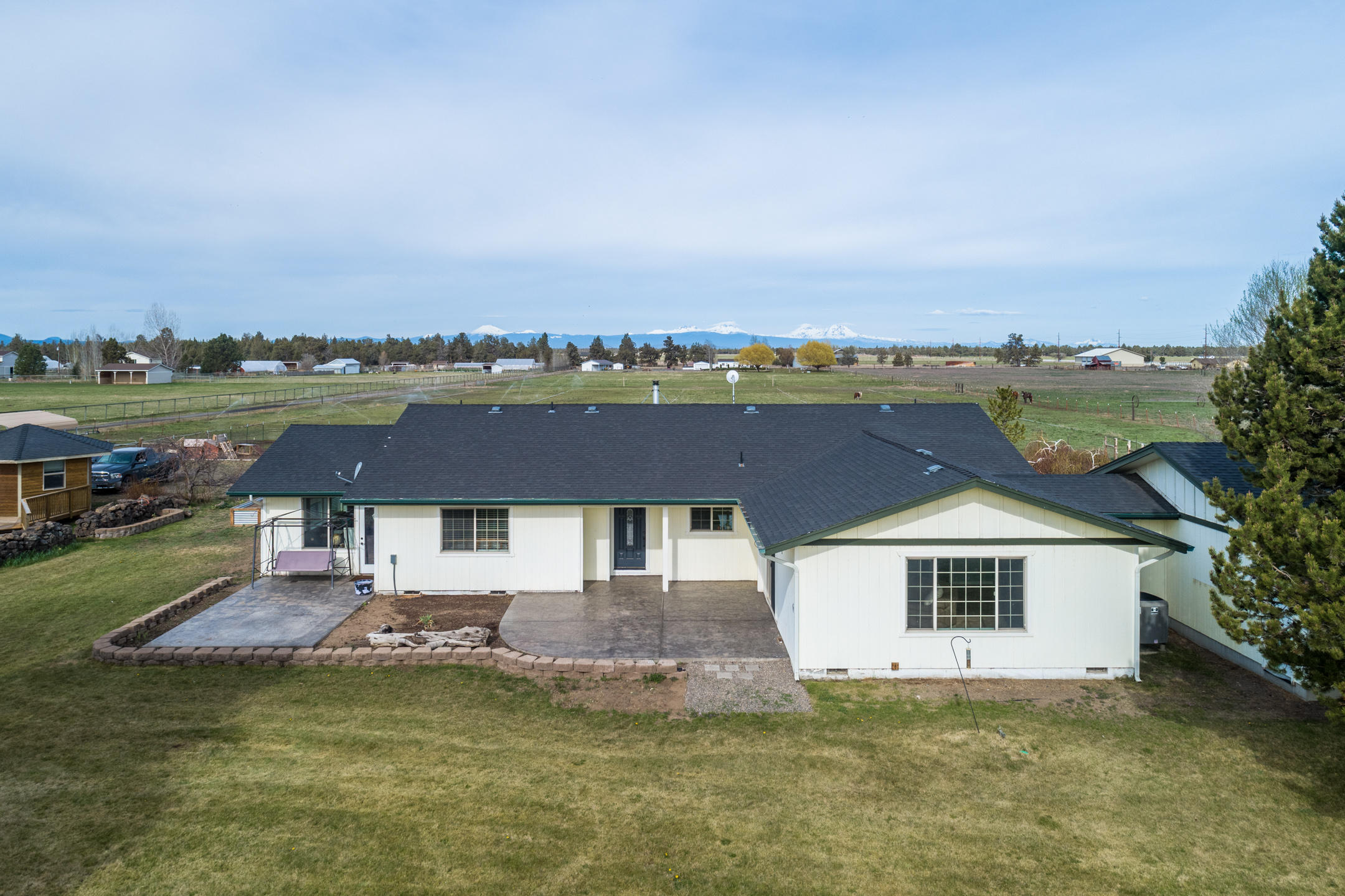 Modern farmhouse just outside of Bend in the heart of the Central Or countryside. Picturesque hobby farm setting w/the Cascade Mtns as the backdrop. Great room style layout w/great separation & must see details! Shiplap walls, rustic fixtures, designer paint colors too. Open kitchen w/central island & tons of cabinets, adjoining dining are & living room w/cozy wood burning fireplace. Master Ste opens up to sun/bonus room. 2 additional bedrooms + office/bedroom @opposite end of home. Mudroom/walk in pantry lead to a flex room that could easily transform to 1 bedroom/studio aptmt! Enjoy out doors year round w/covered patio space. Outside you'll appreciate the hobby shed &  1800 sf Shop w/attached RV cover. Irrigated pasture is fenced & cross fenced for horses & livestock. Dry lot area too! Pull around driveway, dbl car garage, outbuildings, country style sprawling lawn & room for all your toys & critters. Come enjoy the sunsets over the Cascades here!