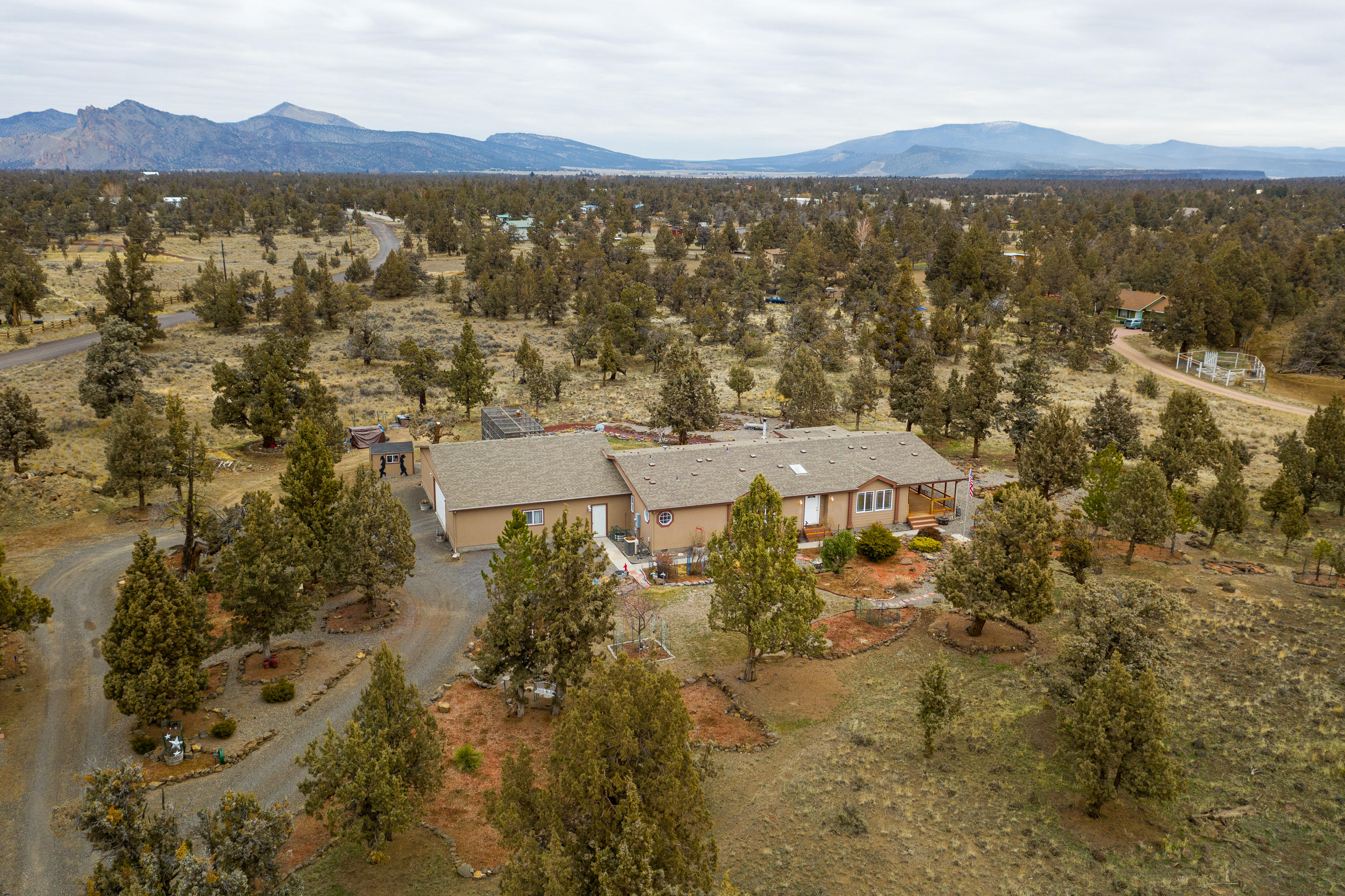 What a LOCATION! Just miles from Smith Rock this Lake Park Estates property is quiet, private yet close to town. Home is a well-cared for triple wide that is light, bright, with lots of windows, huge kitchen, family room, living room, office and three large vaulted bedrooms. Also there is a 1728 sq ft attached garage with two separate rooms that can be used for exercise or hobby/shop. There are two small shed and an attached cattery or dog run. This is a must see property! Welcome Home!