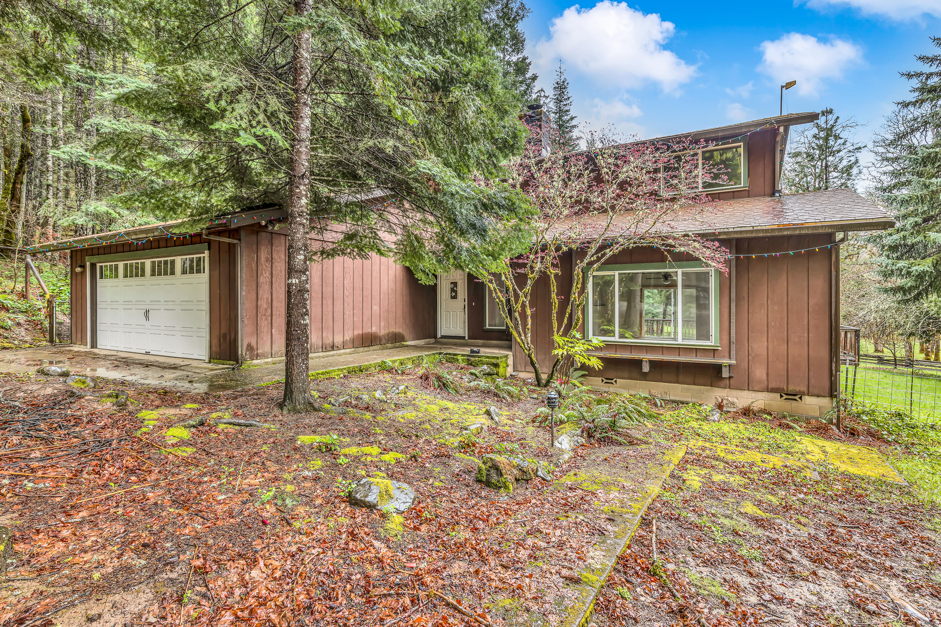 43 acres-2 dwellings in beautiful Sunny Valley!
Cozy up in the NW Style home that has 3 Bed/2 bath with wrap around cook's kitchen and 2 car attached garage. Behind this home is a fenced yard with a patio deck perfect for entertaining. 2 bed/1.5 bath guest quarters with attached garage and a vaulted porch are perfect for enjoying morning coffee overlooking the terrain- also with a fenced yard with raised garden beds. Landscape around the homes is indicative of the redwood/coastal terrain and is gorgeous being backed up by BLM land. Each place has its own propane generator with 500+gallon tank. There are 2 RV hookups, Pastureland, fencing, 50+ raised garden beds with drip systems, and multiple ponds. Seasonal creek runs through your property and Graves creek runs along the properties border. Legend says there was a personal air strip there in the 70's. 2 huge warehouses, several shops, fenced and cross fenced areas make this the perfect place for anything you can dream of.