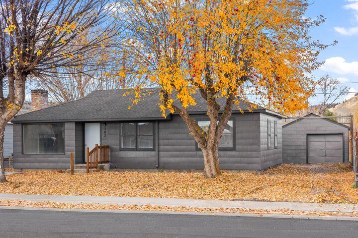 Come take a look at this 1951 charmer on a picture-perfect, tree lined street in the heart of Prineville. This home has so much charm and character and features 3 bedrooms and 2 baths with 1,692 sq ft. It has original hardwood floors, living room fireplace w/wood stove insert, charming original kitchen with metal cabinets, vintage stove top and farmhouse sink. Large laundry room with tons of storage cabinets. Generous great room was added which could be utilized as a family room, homeschool room, extra bedroom, whatever you need! Property was just freshly painted inside & out, and has a detached garage with work bench and storage room inside. Yard is partially fenced with mature shade trees, fruit trees, and plants. Quiet street with lots of extra parking.