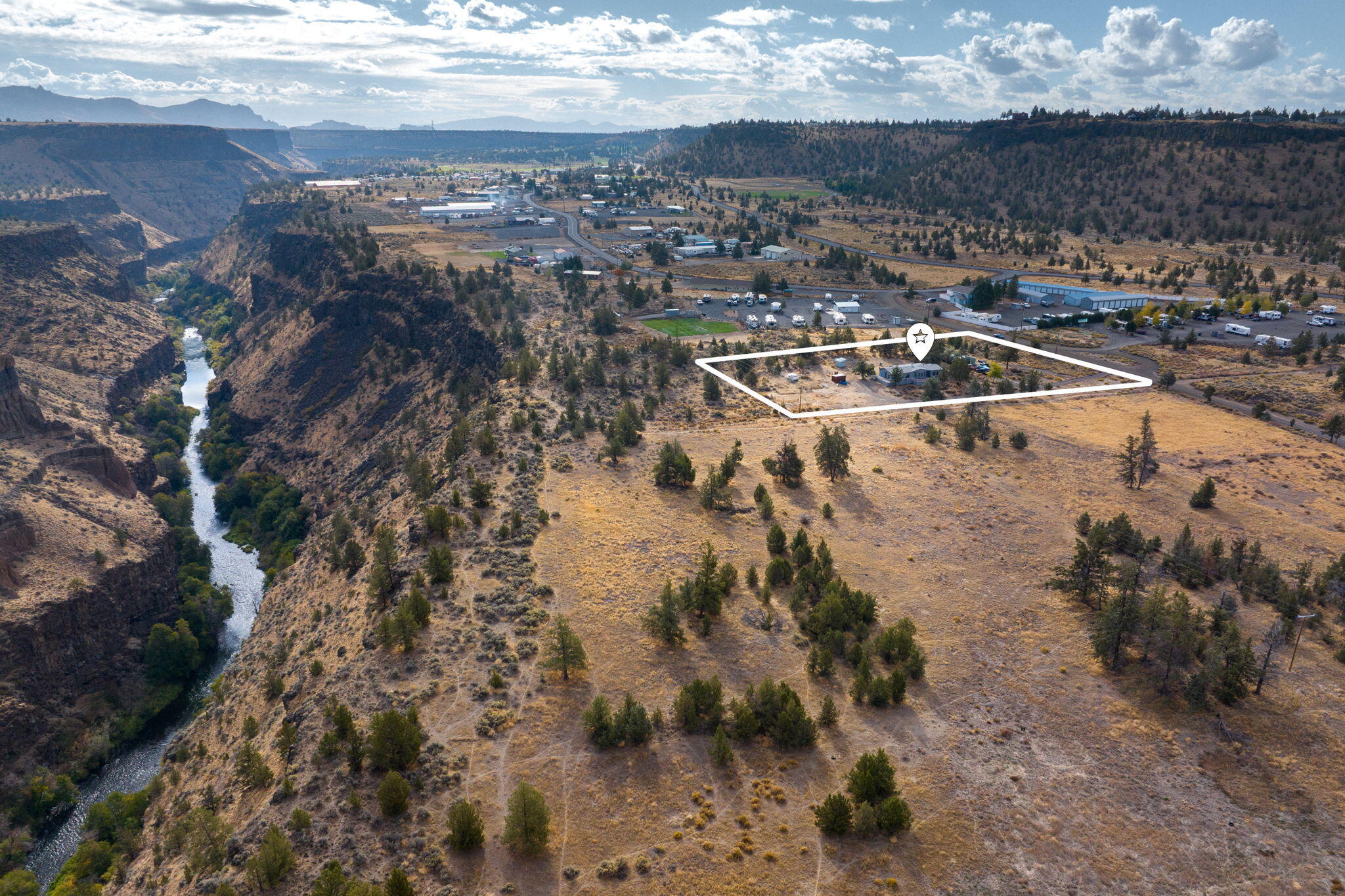 Discover the perfect live-work opportunity in the heart of Crooked River Ranch! This unique property sits on two commercial lots with breathtaking canyon views overlooking the winding Crooked River. The home offers a flexible layout ideal for both living and business use that current zoning allows for, featuring dedicated office/shop space and multiple outbuildings ready to support your vision. Enjoy close proximity to golf, swimming, tennis, hiking, and fishing - all within walking distance. Whether you're looking to operate a business, generate income, or create a dream retreat, this property offers endless potential. Priced with room for improvements, this is a rare chance to own a slice of Crooked River Ranch paradise.
