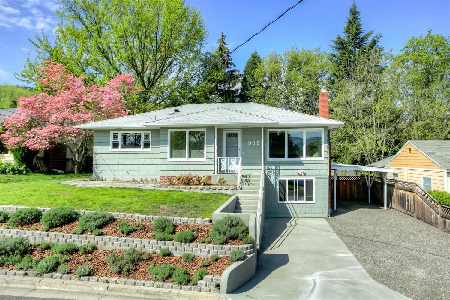 Charming Ashland 50's cottage in a lovely, quiet neighborhood! Beautifully renovated over the past few years, this spacious home includes classic hardwood flooring, sunny dining and living rooms with fireplace and a graciously updated kitchen with Hickory cabinets, granite countertops, artistic lighting, and eating bar. The home has a wonderful layout with two bedrooms and two tile baths on the main level, plus a spacious bedroom, office, family room, and separate entrance on the lower level. The very private back yard offers mature trees, flowering Dogwoods, flagstone pathways, rock garden, raised deck with views of Grizzly Peak and a nearby seasonal irrigation creek. And don't miss the new thermal windows throughout, hi-efficiency furnace, extra insulation and attic venting system Mid-century charm updated to modern taste and efficiency -- what more could you ask for?