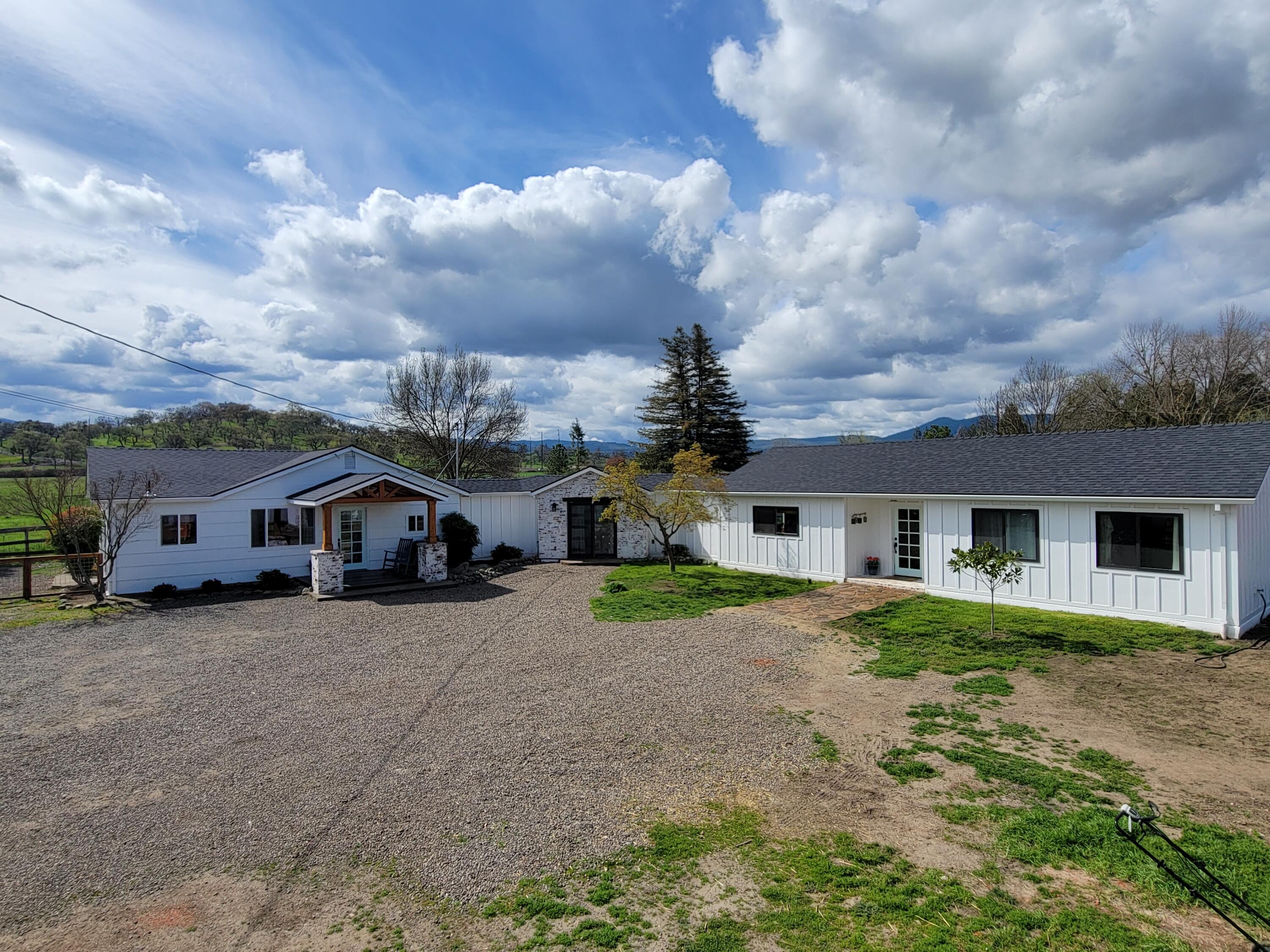 So much opportunity with this property.  Awesome single family property -or- live in one side and rent the other -or- in-law set up -or- vacation rental -or- possibly traveling nurse rental...take a look and decide for yourself! Fantastic farmhouse in a prime Southern Oregon location offers beautiful pastoral and mountain views.  Situated on a large, fully fenced and gated lot, this property is located minutes to Jacksonville and in close proximity to wineries, organic farm stand and much more.  Original home was completely remodeled in 2017 and the new addition was added in 2020.  Property offers tons of parking, a new storage shed, 2 wells (original well with holding tank and a new well that produces 10+gpm), a great patio off the living room and lots of room to play.   Home offers 2 living rooms, 2 dining areas and 2 laundry rooms and offers a beautiful sunroom. This property has so much to offer...Don't miss this one!