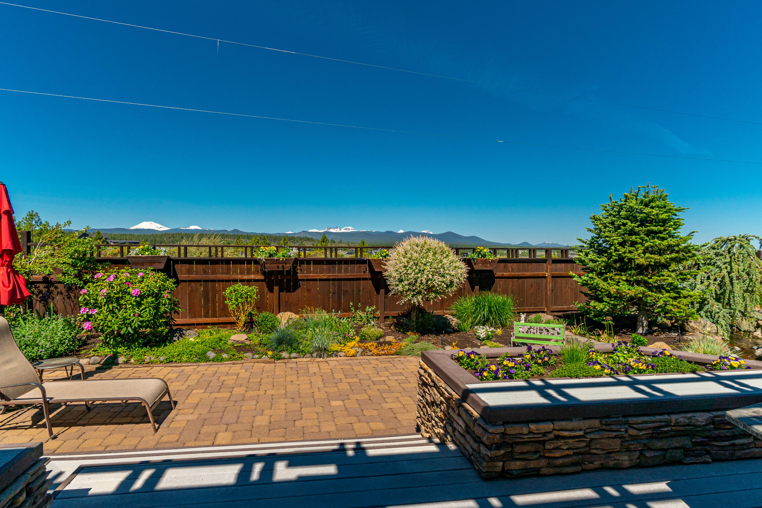 Come home to your own private sanctuary with unsurpassed mountain views  & stunning sunsets. One of a kind Westside location in the coveted 1st on the Hill neighborhood, across the street from 14 acre Alpine Park where you'll find direct single track trail to Phil's Trail system & the River Trail as well as easy access to Mt. Bachelor & the Cascade Lakes. An immaculate home, with numerous recent upgrades and countless unique design details from hand forged iron elements to an inlaid wood & tile bar.  Great room fully captures the view from chef's kitchen with oversized island to living area with stack stone gas fireplace. Main level primary has direct deck access, custom birdseye maple vanity & full tile shower.  2nd level features second primary suite with those breathtaking mountain views & corner office. Two guest beds, full bath & large laundry complete the main level. Plenty of room for your RV & toys on this .63 acre lot with add'l detached 26'x20' garage/shop & 60' parking area.