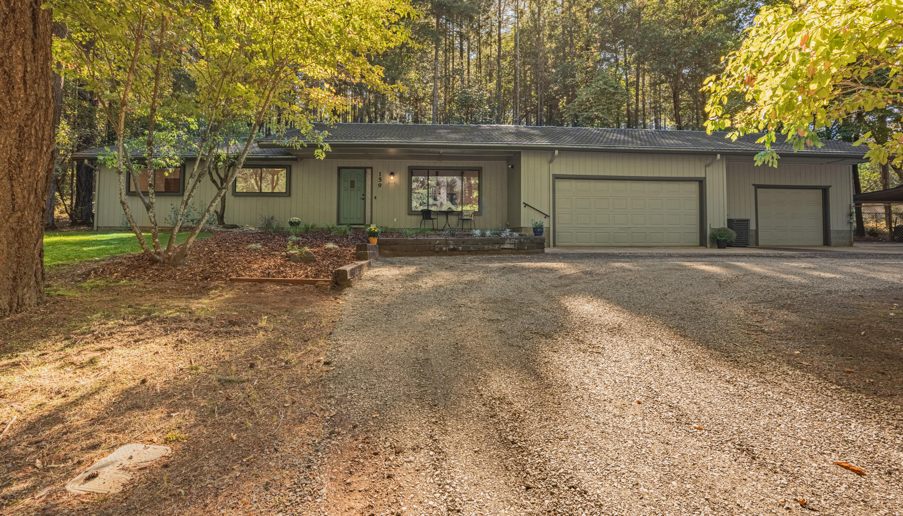 Nestled on 2.86 acres of lush woodlands in this 3-bed, 2-bath home spanning 1652 sq ft. Recently revitalized, it features fresh paint, new appliances, and new flooring. The airy kitchen, equipped with a convection oven, adjoins a dining room and living space, complete with an eat-in bar. The primary bedroom is bright and airy, with sliding glass doors that lead to serene outdoor views. The spacious primary bathroom offers extra storage. Hobbyists will relish the 110v-powered shed and a 3-bay heated garage with 220 power. According to the Oregon well log, this homes well yields 20 GPM.  The house features a circle drive, carport, RV hook ups with dump, and partially fenced yard, making it perfect for those who desire a peaceful lifestyle.