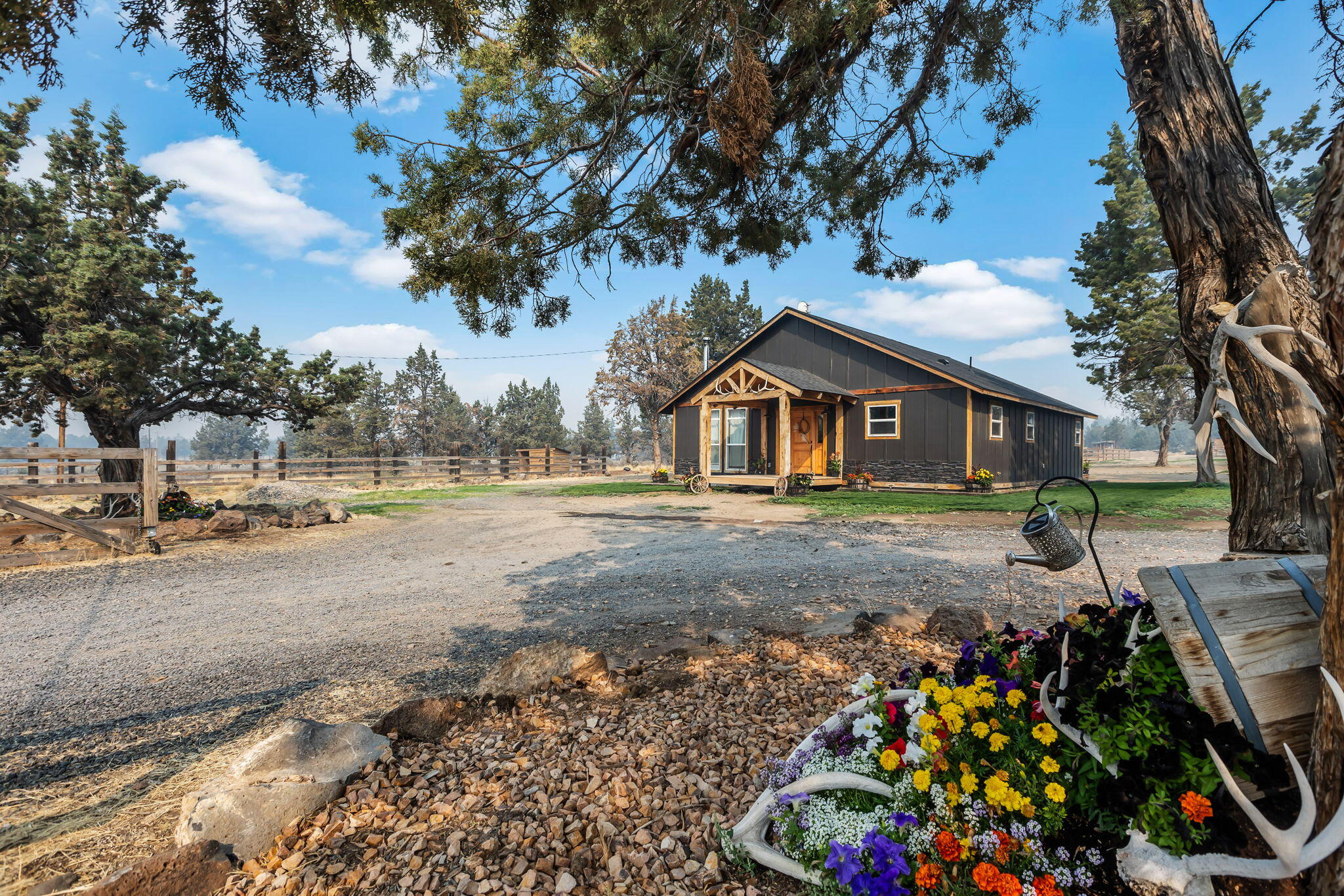 **Charming** and completely remodeled, this nearly 5-acre property is a perfect blend of modern comfort and rural charm. Located just minutes from downtown Prineville, it offers the tranquility of country living with easy access to shops and dining. This inviting 3-bedroom, 2-bathroom home features a spacious master suite with a luxury bathroom, ideal for relaxation. Enjoy the stylish laminate flooring throughout, leading to a huge back deck perfect for entertaining or enjoying peaceful evenings by the fire pit. The rustic front porch adds character, while the chicken coop and raised garden beds cater to your homesteading dreams. Horse enthusiasts will appreciate the barn with 3 stalls w/run and outdoor arena. With a lush grass area complete with a playground, this property is perfect for families seeking outdoor fun and space to roam. Embrace a lifestyle of comfort and convenience—don't miss your chance to make this dream home yours!