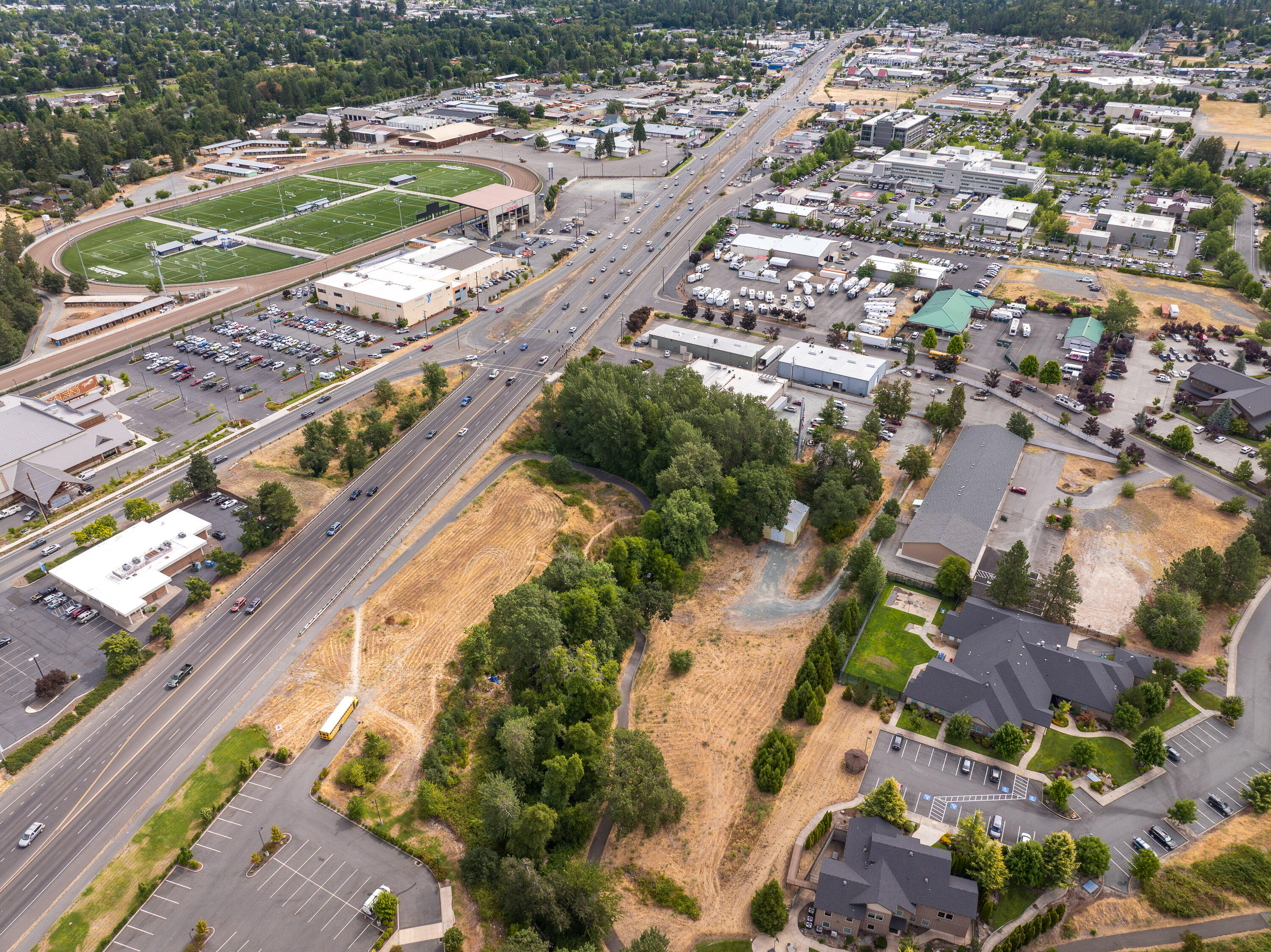 An exceptional commercial development opportunity in one of Grants Pass' most strategically positioned growth corridors! Located in the heart of the Redwood area and just minutes from Asante Three Rivers Medical Center, this 2.02-acre parcel offers prime visibility and connectivity—ideal for medical, professional, or service-oriented commercial ventures.
The property enjoys just over 600 feet of frontage on scenic Allen Creek and direct access to the Allen Creek Trail, providing possible foot traffic and  integration with the surrounding community. Zoned General Commercial (GC), the site supports a wide range of commercial uses—including retail, office, multifamily mixed-use, and more—with generous development allowances.
A 1,440 SF shop building on site offers immediate utility—perfect for contractors, trades, storage, or interim workspace while development plans are underway.