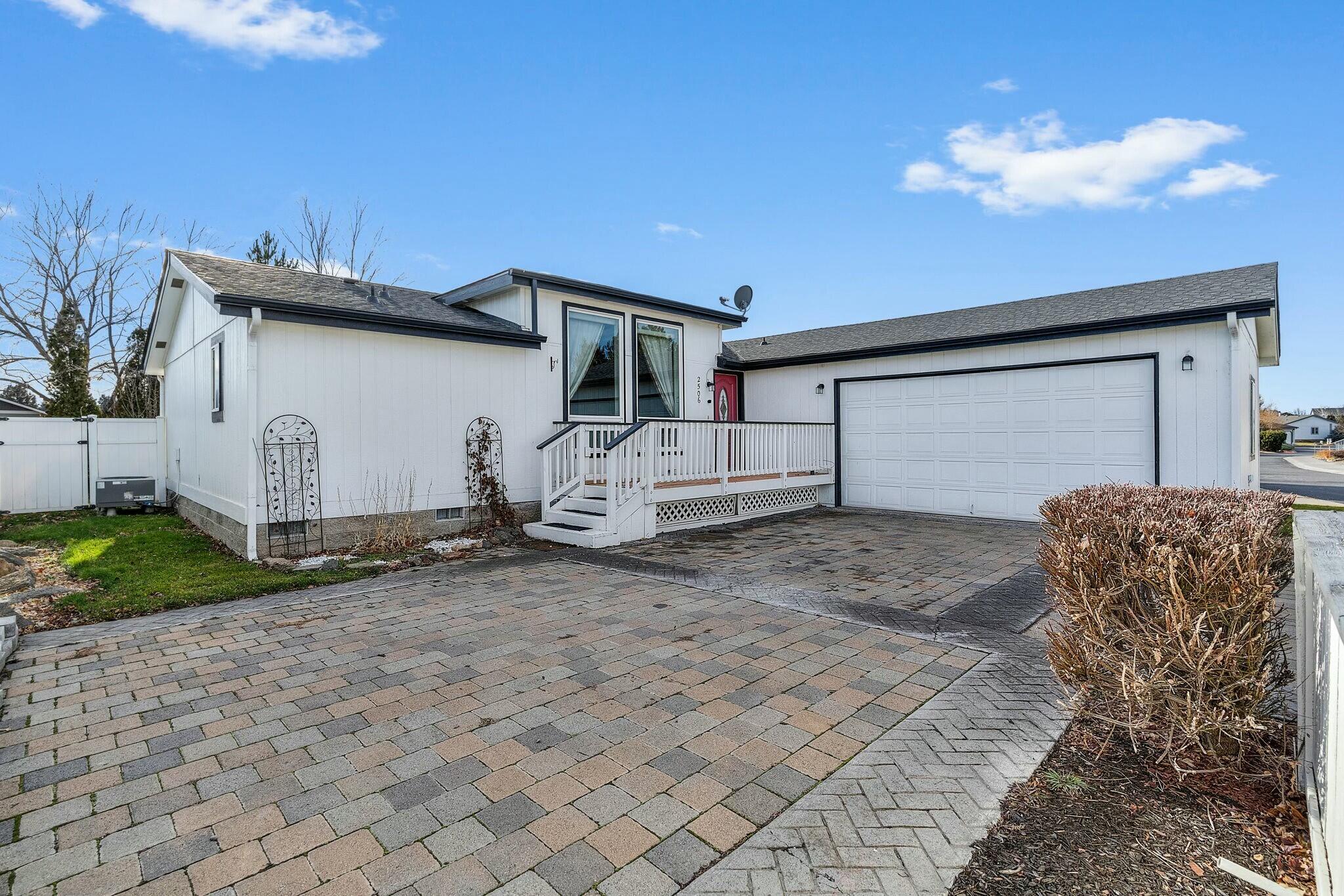 Located in the heart of Redmond! This 1753 sqft triple wide MF home boasts an open floor plan w/large windows vaulted ceilings a skylight that fills the space w/natural light and tongue & groove wood wainscoting adds warmth and character to the home. A spacious kitchen features an island built-in pantry breakfast bar dining area & flows into an additional living room w/a gas fireplace. The fenced backyard offers privacy & outdoor space for relaxation. Retreat to the primary bedroom w/a walk-in closet double vanity soaking tub & French doors leading to a private deck. Two additional bedrooms are generously sized each w/walk in closets & share a hall bathroom. The laundry room leads to an oversized 2 car garage w/a workbench & plenty of storage space plus extra parking on the backside of the garage. Recent updates in 2022 include a new roof exterior paint all kitchen appliances flooring baseboards propane tank French doors & a doggie door. Move in ready & low maintenance. Call today!