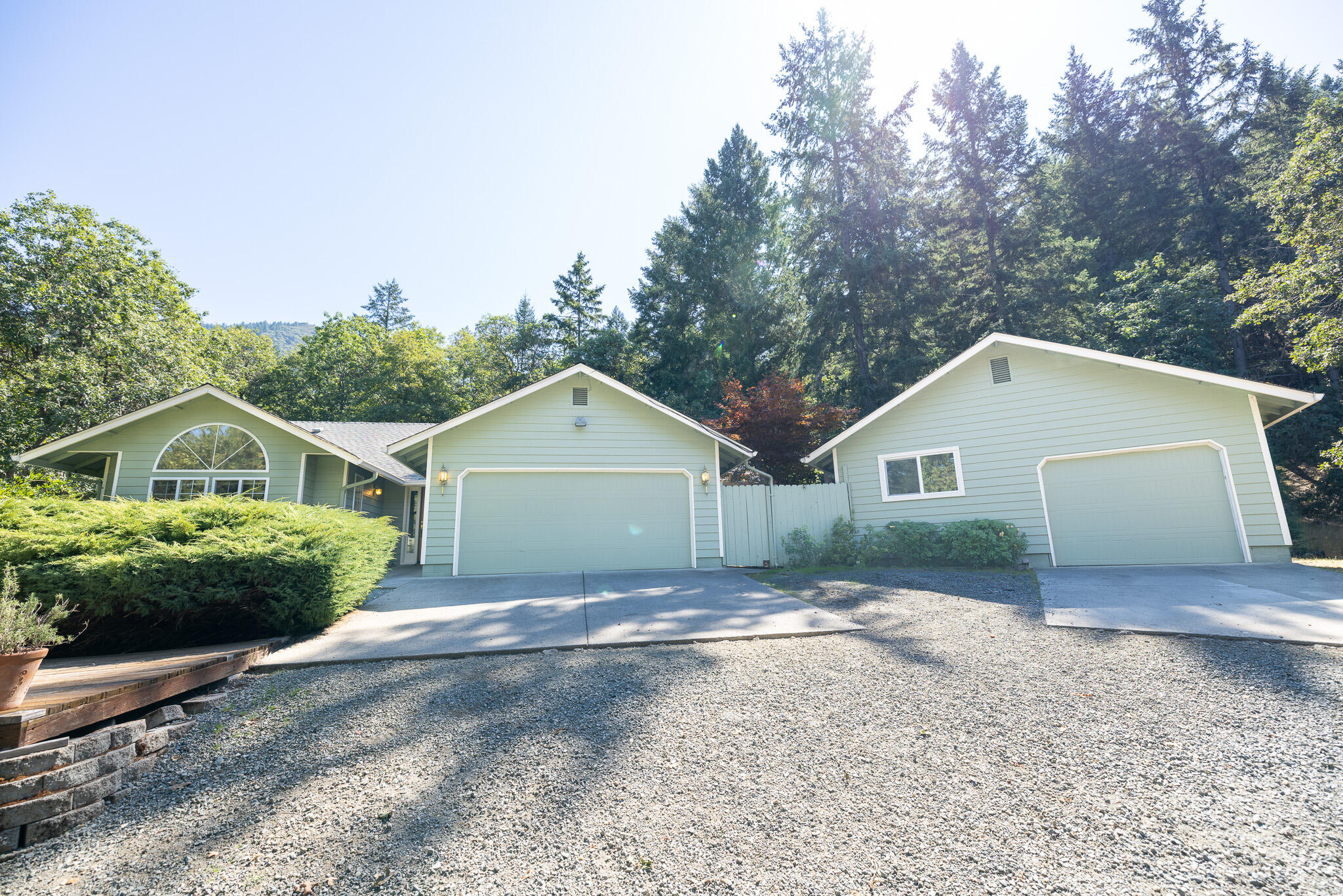 Peaceful single-level living in a serene wooded setting! Updated in 2014, this 3 bedroom, 2 bath home  offers 1,729 sq. ft. of comfortable living on over 2.5 acres, split between two tax lots. The main home sits on 1.36 acres with an additional 1.23-acre parcel included.
Enjoy mornings surrounded by wildlife from the covered back patio or the private porch off the primary suite. Inside, a spacious living room with a large picture window fills the home with natural light, while a cozy woodstove creates a warm and inviting atmosphere.
The fenced backyard with raised garden beds is ideal for outdoor living and gardening. An attached 2-car garage adds convenience, while the detached 768 sq. ft. garage/workshop with woodstove provides room for projects, storage, or potential as an accessory dwelling unit.
Recent well flow test shows 19 gpm. All this in a private, rural setting just 12 minutes from Asante Hospital and shopping offering both tranquility and accessibility.