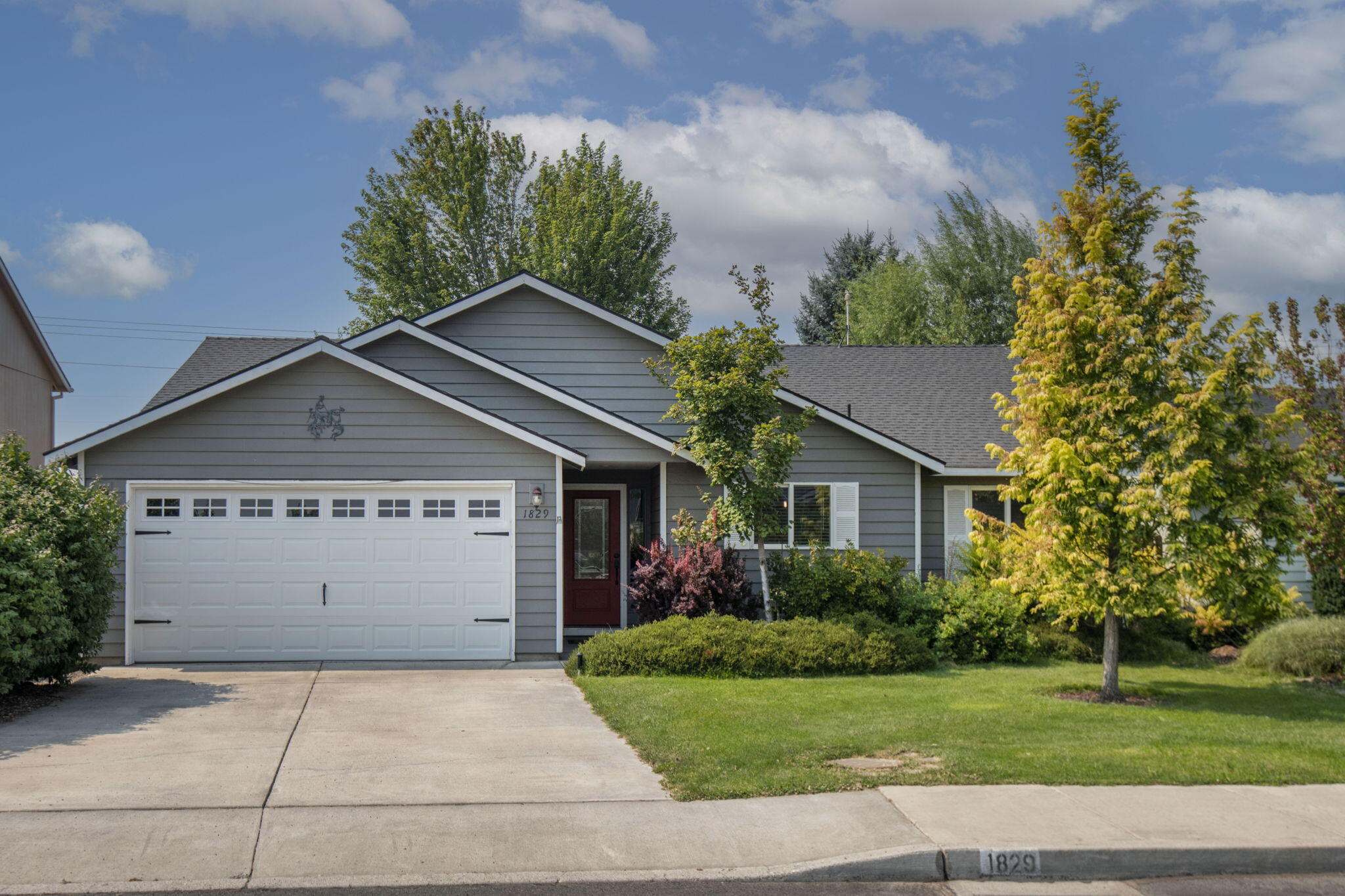 Welcome to this beautifully maintained single-level home offering three bedrooms and two bathrooms. The thoughtful floor plan provides excellent separation between the primary suite and secondary bedrooms. Inside, you'll find a dining area and a separate living room with a cozy gas fireplace—perfect for both everyday living and entertaining. The freshly painted interior creates a bright, welcoming atmosphere, making this home truly move-in ready. Step outside to your private retreat: a lush backyard with mature landscaping, a tranquil water feature, garden beds, and a storage shed. Whether you're relaxing, entertaining, or simply enjoying the Central Oregon seasons, this outdoor space has it all. Ideally located near parks, schools, shopping, and Redmond's vibrant downtown, this home combines comfort, convenience, and charm in one inviting package.