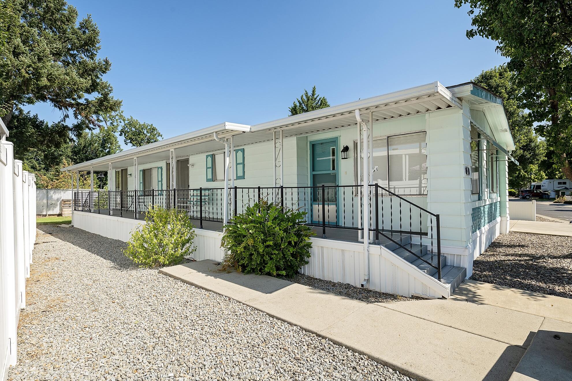 Seller will pay two months rent to new owners! Spacious 1368 square foot home  that has been meticulously maintained, upgraded and artistically decorated and
loved. This home is SO much nicer than one would expect! Large kitchen, an
island with gas stove top,  dining room and breakfast bar are just a few of its desirable features. The primary suite has
its own full bathroom, and is super nice. Front door opens to a really big living room and there is
also a good sized den/family room off of the kitchen. The second bedroom is good sized and has a walk in closet too, and
adjoins a full guest bathroom. Full covered deck along the front entrance, along with a back entrance porch adjoining the 2 car carport. Large yard is mostly low maintenance, and has great areas for gardening if desired: the  remaining lot is pebbled stone. The shed is set up with a workshop area too. Newer heat pump, lighting fixtures and appliances