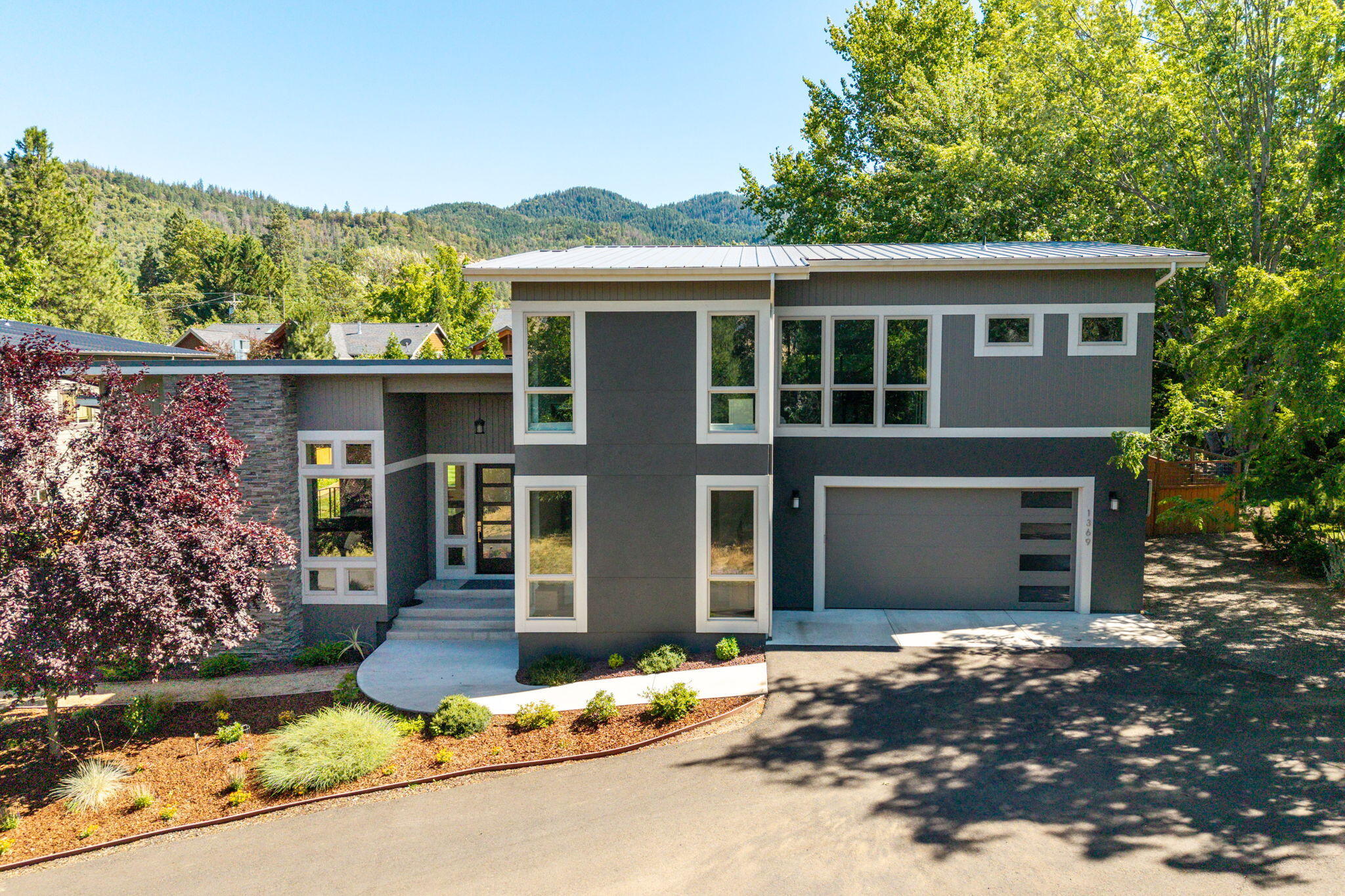 Nestled on a private lane shared with just two other homes, this inviting contemporary residence offers a perfect blend of style, comfort, and privacy. Designed and built in 2017, the home features an open, light-filled floor plan with lovely hardwood flooring. The gourmet kitchen is a chef's dream, complete with granite countertops, an expansive eating bar, and custom-painted cabinetry. The great room is a showstopper with soaring ceilings, a charming fireplace, and expansive windows that bring stunning mountain views and natural light indoors. The main level is home to a peaceful primary suite, a versatile second bedroom/office, 2nd full bath, a convenient laundry room, and a 2-car-attached garage. Upstairs, you'll find two additional bedrooms, a 3rd full bath, and a spacious bonus room that can be tailored to your needs. Set on a .39-acre landscaped lot with w/ raised garden beds, a fully fenced backyard, deck, and TID irrigation rights—this home is an absolute must-see!
