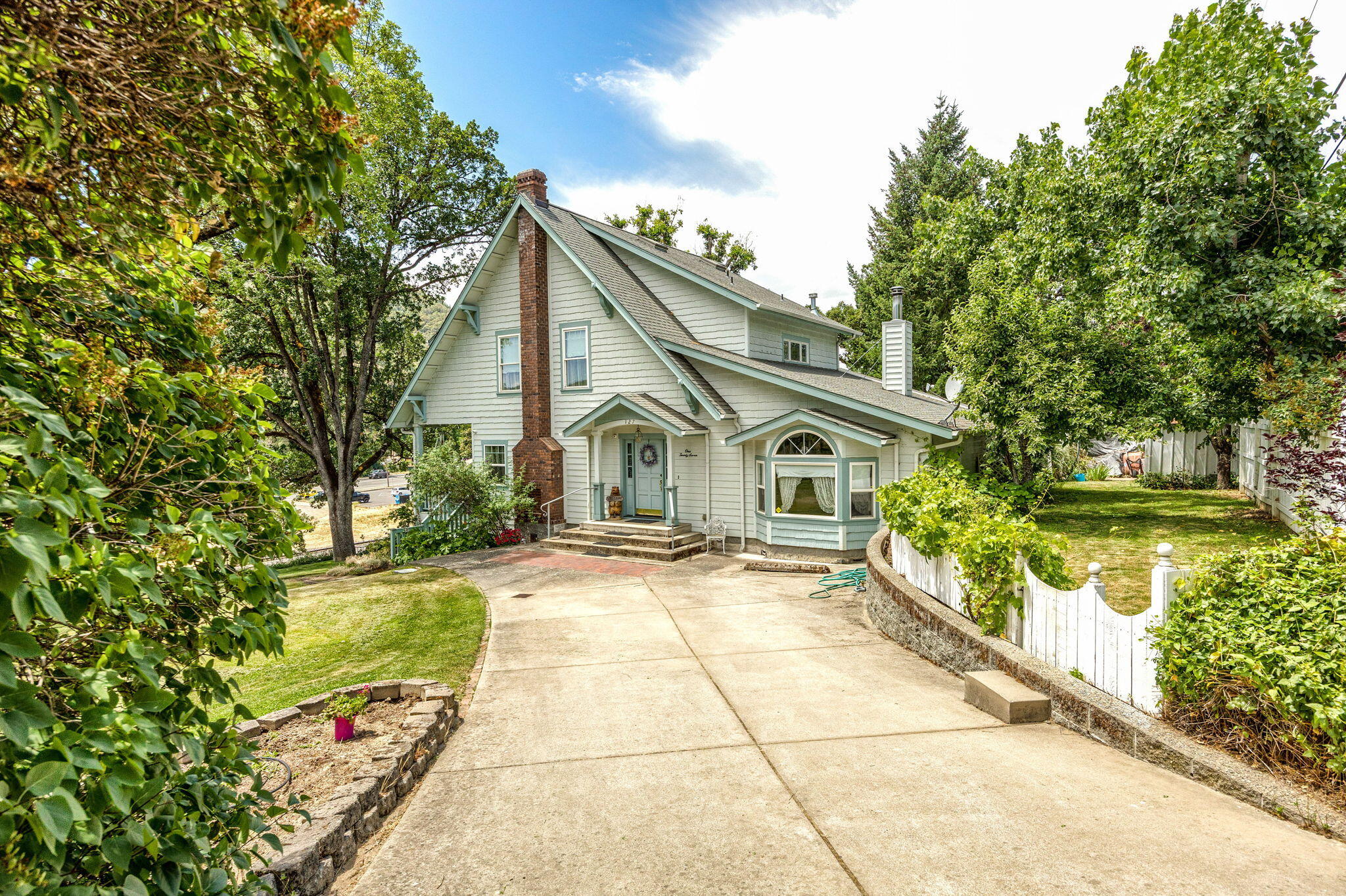 Tucked away in the heart of Gold Hill, this thoughtfully rebuilt home at 127 4th Avenue blends modern comfort with the character of a classic residence once owned by Gold Hill's first banker. Designed as a modern replica of the original home that stood on this very lot, today's version offers a warm, light-filled layout, efficient systems, and a timeless charm that's hard to find. The property spans multiple lots, creating opportunities for a future garage, expanded outdoor space, gardening, or additional parking. The unfinished basement adds flexibility and may offer potential for an ADU or creative (buyer(s) to do all due diligence). Outside, enjoy a private backyard, off-street parking, and walkable access to the Rogue River, parks, and the small-town charm that makes Gold Hill such a hidden gem. Whether you're looking for your first home, a quiet place to call your own river retreat, or are seeking a low-maintenance investment in a growing area, this one is worth a closer look.