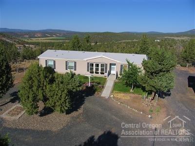 Quality Palm Harbor home, hill top location with panoramic view of surrounding terrain and lots of privacy. Open FLR plan with living RM family RM and split bedroom. Certified wood stove for our Central Oregon winters. Central kitchen with sky light for lots of natural light. Separate master suite with walk-in closet, double sink bathroom with soaking tub and step-in shower. 36x24 shop with 220 power and lots of storage, plenty of room for all the toys. All this on 2.03 acres and just minutes to town.