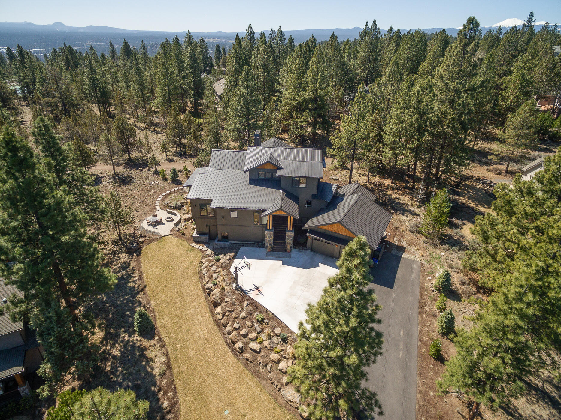 Step into the extraordinary at this luxury Awbrey Butte home. The gorgeous great room is centered by the floor to ceiling stone fireplace with views of pines all around. White quartz counters & stunning island, high end appliances & walk-in pantry create the dream kitchen. The main floor master wing begins in the large office to the luxury bath with spa amenities: steam shower, soaking tub, double vanities & the ultimate closet. The bedroom itself is very private and generous too. Main floor guest suite, 2 upper bedrooms & a huge lower level bonus room for movie night and activities!