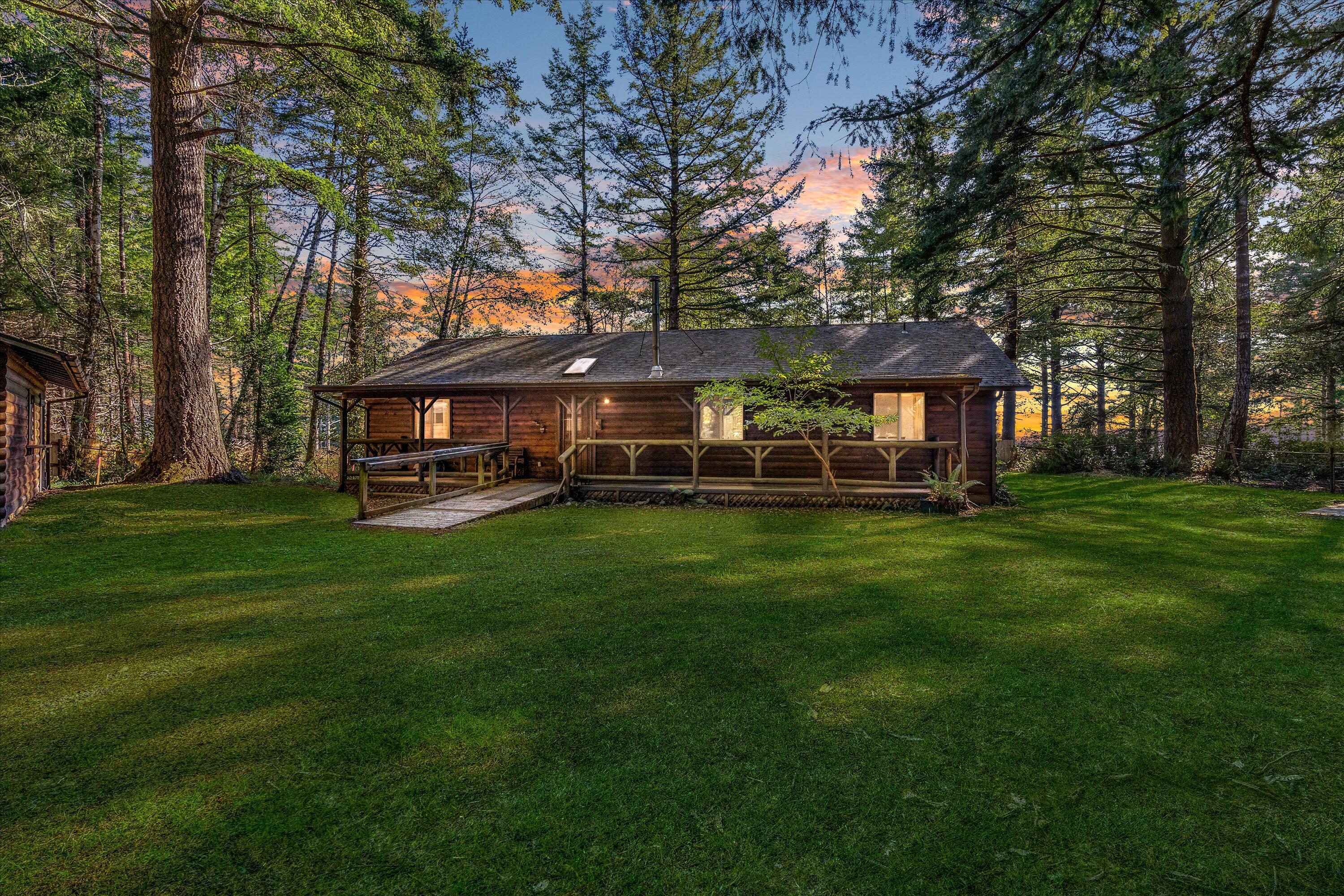 Charming log-style home on a gated, forested lot, complete with garage and shop! Cozy up by the wood stove, or take a
dip in the indoor hot tub as you enjoy a partial ocean view. This home features high ceilings, a large bonus room with french
doors, privacy, and plenty of space to spread out both inside and out. Enjoy the covered porch and the sounds of nature, only a
short drive to the beach.