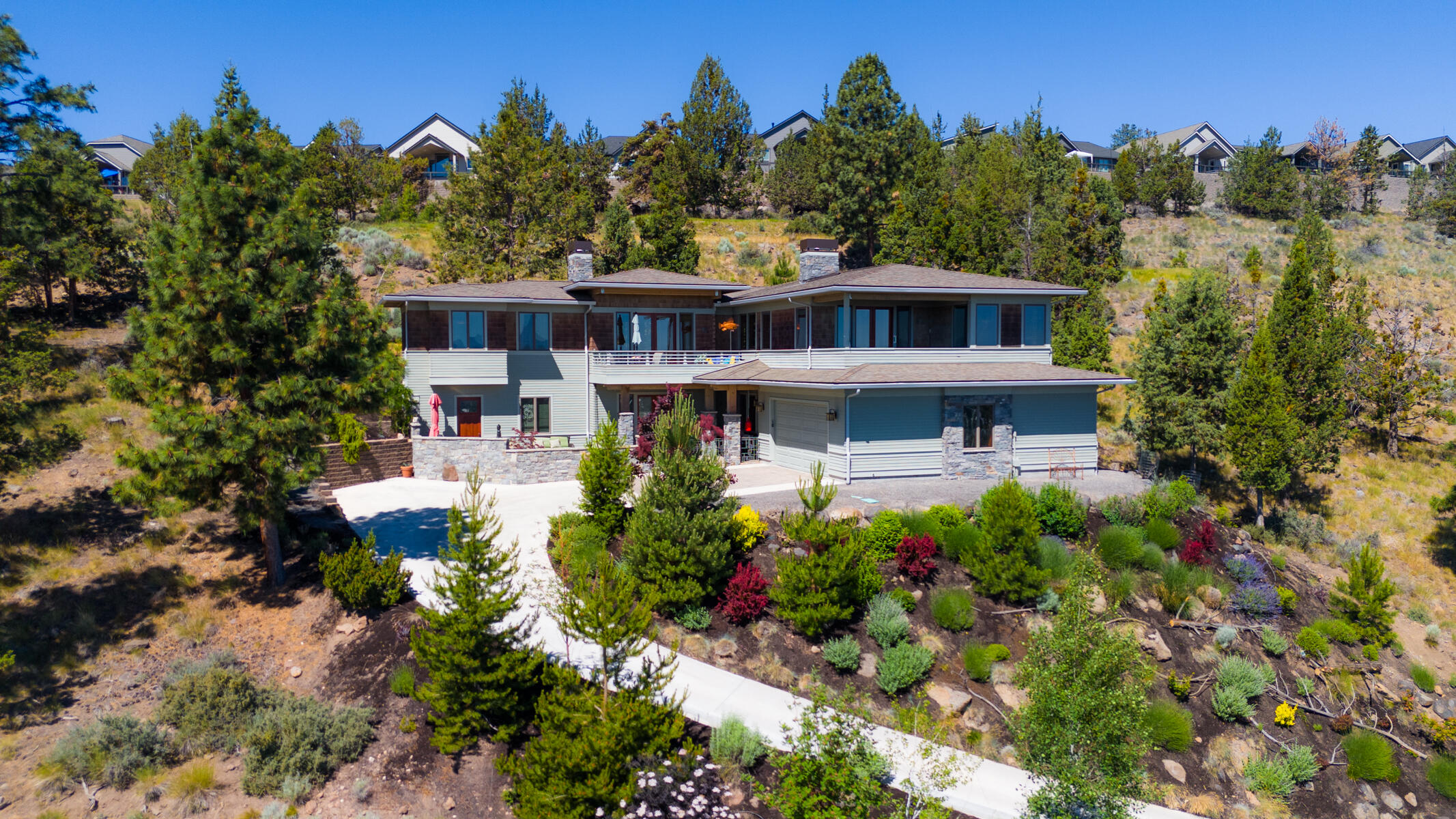 Easy access to stunning views with this climate controlled heated driveway. An exceptional, Frank Lloyd Wright inspired home, sits on 0.35 acres, offering stunning easterly views & a peaceful sanctuary adjacent to the Rivers Edge golf course. Built in 2015, the home features 4 BR, 3 full baths, and 3,562 sqft of living space. The heart of the home is the inviting great room w/ a striking stone-faced fireplace, perfect for gatherings. Multiple outdoor balconies and patios invite you to unwind in the serene natural surroundings. The lower level offers versatile space, from living areas to a workspace or art studio. Charming antique hardware accents blend seamlessly with marble and granite countertops, exuding elegance throughout the property. Enjoy the convenience of an interior elevator, hot tub & sauna, providing the ultimate in luxurious living. This energy efficient home boasts a remarkable home energy score, ensuring sustainability w/out compromising comfort.