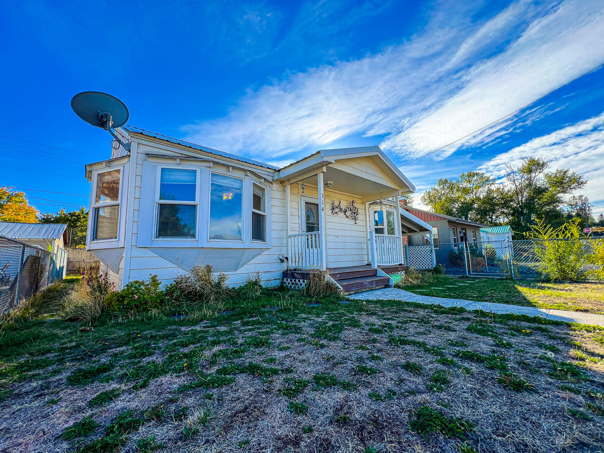 This charming home is perfect for first-time buyers, retirees, or as an Airbnb. Conveniently located in John Day, just minutes from downtown, this 1949 home offers 1,056 square feet and features 2 bedrooms and 1 bathroom. The living room opens to the kitchen, which has a cozy eatery. The original kitchen cabinets extend to the ceiling, complemented by tile countertops and flooring. There are multiple built-ins for storage. One bedroom comes with a walk-in closet. The bathroom offers a jetted tub with a tile surround and a spacious tile vanity. The laundry/mudroom is spacious being approximately 124 sq ft with built-in storage.

Additional features include multiple outbuildings, such as a hot tub room and a 384-square-foot storage area that is half-finished, ideal for a flexible space. There is also a hickory shed with shelves for extra storage and a large carport for covered, off-street parking. A covered patio is perfect for year-round enjoyment. Flood Plain.