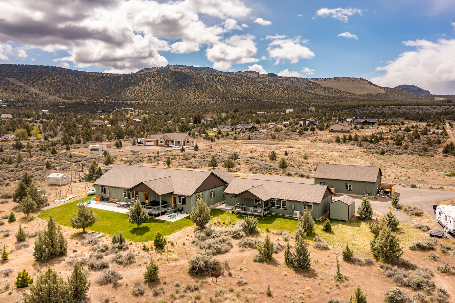 Experience luxury and versatility in this 2019-built home on nearly 5 secluded acres! With a combined 3,491 sqft of living space, comprising a 2,412 sqft 3 bed 2 bath main house and a 1,079 sqft 1 bed 1.5 bath separate addition , this property caters to multi-generational living. The main house showcases vaulted ceilings, oak wood floors, and a gourmet kitchen with quartz countertops, double oven, 5 burner propane range, pantry and large island that opens to the spacious great room. Entertain on the covered deck with stunning views and an open patio with a custom flagstone fireplace. A spacious garage with heated storage adds convenience. The addition, designed for multi-generational use, features wide doorways, mini split HVAC, ADA accessible features, a separate laundry room with half bath, and a private deck. Outside, discover a heated 30x40 shop with plenty of power, RV parking w/ 50amp plug and water, 10x16 shed, 10x12 greenhouse, and chicken coop, offering endless possibilities