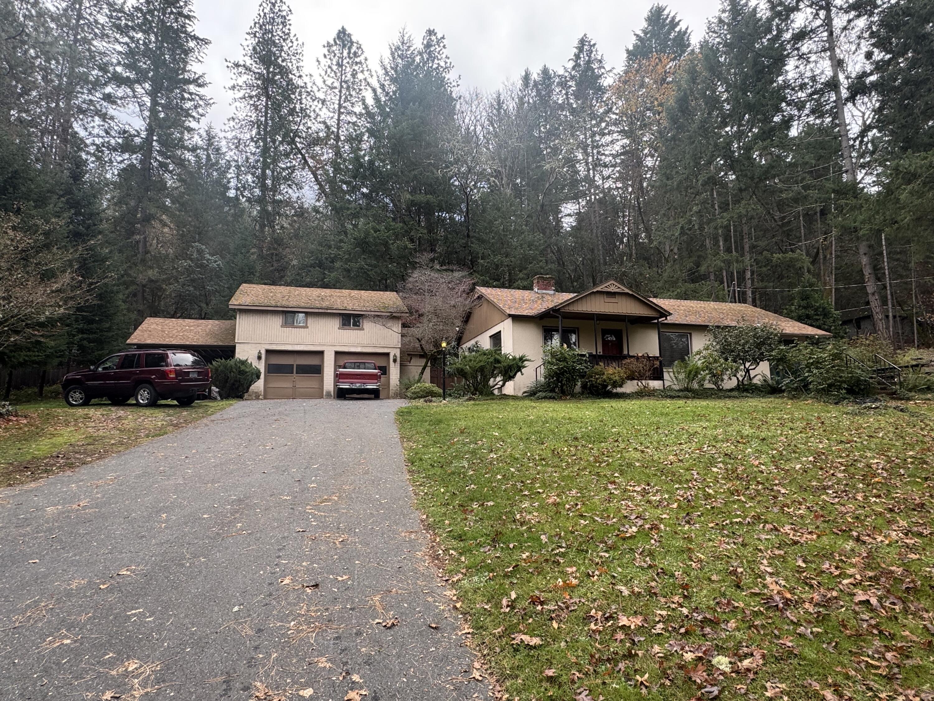 Wonderful 3 bedroom, 2 bath 1,502 SF home in Park Like setting across from the Rogue River. BRAND NEW SEPTIC INSTALLED. Property Includes 130 LF Direct River Access & small beach just across the road. Effective Remodel in 1970 added 3rd room & 2nd bathroom + patio access. Home boasts original tile & wood craftsmanship, brick fireplace, gorgeous Parquet Floors, solid wood cabinets & Oversized Canning/Laundry room. The 2-car garage has electrical in 110 & 220amps for many hobby configurations. Bonus room above has retractable stair access is set up as activity room & could be additional storage or Detached Living Space. Central HVAC installation with new ducting, works for recirculation of fireplace heat just needs heat pump. Home is conveniently located between Grants Pass & Rogue River. Expansive front yard with Mature Trees & a gentle slope create a serene feeling. Home is a touch dated yet Solid Condition Don't miss seeing this quiet beauty for your self