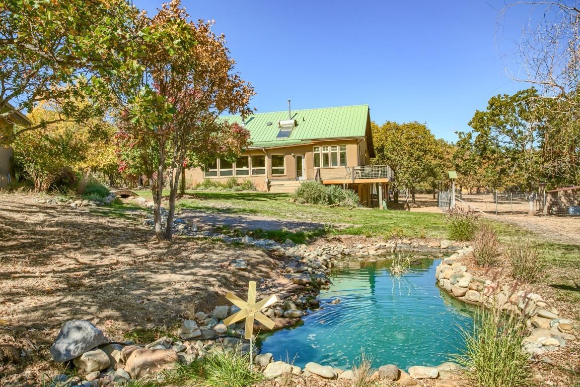 Two-family set-up built in 2002 on 4.08 acres in highly sought-after Jacksonville within a short distance to Applegate River. Main dwelling is 3511 sq ft, 3 bed, 2.5 bath, 3 levels w master bedroom & full bath, kitchen, dining, living, laundry, mudroom on the main; downstairs 2 bed, 1 full bath, storage; upstairs has an office w plenty of storage, half bath & study area. Post & Beam, earthen plasters, straw-bale insulation, Kachelofen masonry woodstove, solar hot water, on-demand water heater & other green features. Includes a wraparound deck, gas stove, radiant floors, skylights, custom tilework & plenty of storage. Detached Adobe studio is 2066 sq ft w high ceilings, 2 large open areas, 2 closed areas, 2 lofts, 1 full bath, attached 1 car garage & covered outdoor sitting areas. Well maintained mostly flat, useable zoned RR5 land, garden area, chicken coop, ponds, well, two-5000 gallon rain tanks, paved basketball court, detached office, covered firewood & expansive views!