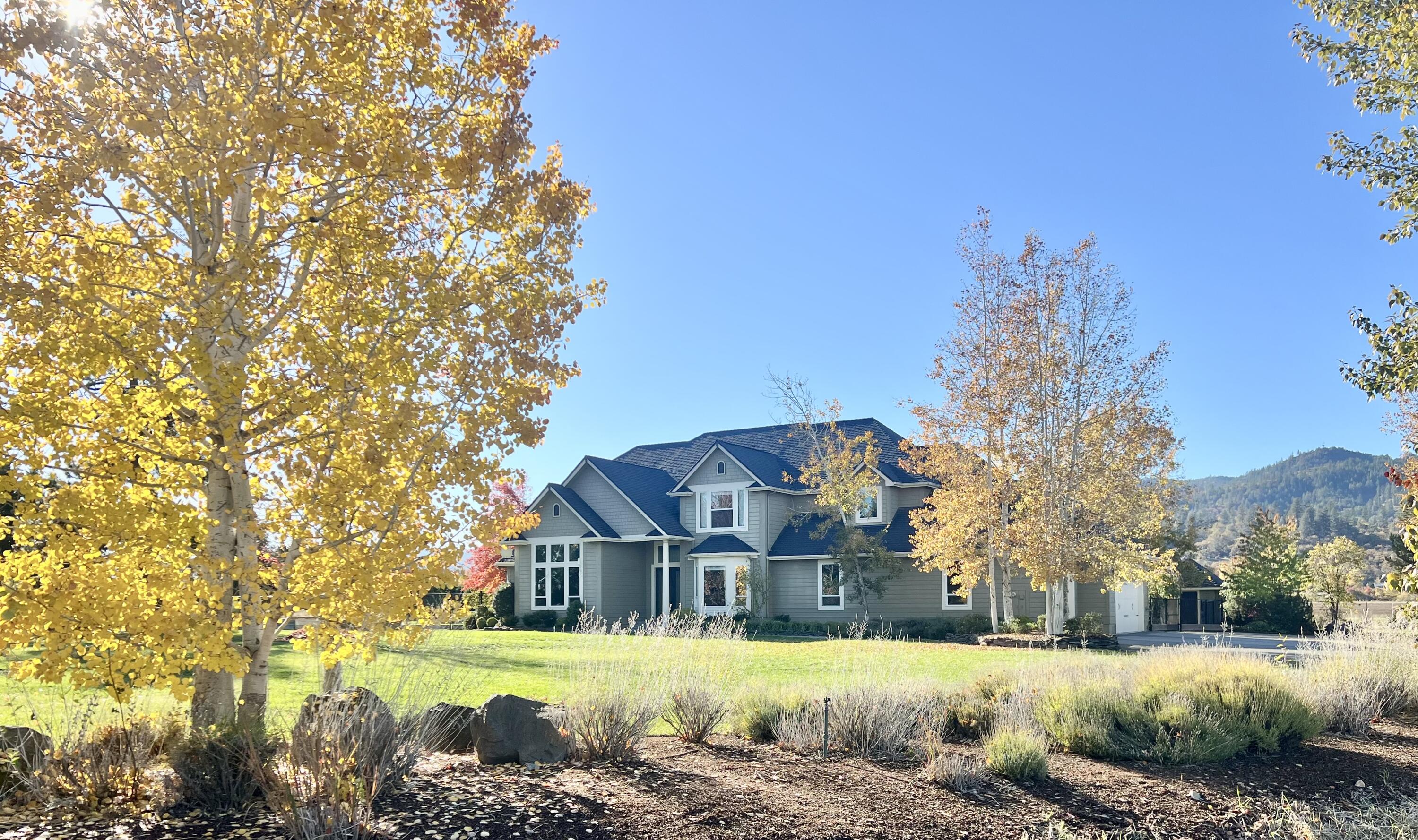 Set amidst 21.5 private acres, this extraordinary equestrian estate offers an authentic ranch experience mere minutes from town. The grand foyer introduces a great room with 25-foot ceilings and floor-to-ceiling windows, showcasing breathtaking views of snow-capped Mt. McLoughlin. A gourmet kitchen is appointed with granite countertops, high-end appliances, three sinks, coffee bar, and butler's pantry with ample storage. The primary bedroom features a lavish en-suite bath, including dual vanities, walk-in shower, soaking tub, and walk-in closet. Three spacious bedrooms upstairs — two with en-suite baths — enjoy lovely views of the Rogue Valley. The heated barn includes tack room, laundry room, three stalls with covered runs, & grooming bay. Additional amenities include two outdoor arenas, pivot irrigation system, paddocks with loafing shed, covered hay/trailer parking, two-car garage/shop with guesthouse and a spacious patio complete with koi pond.  Too  much to list here!