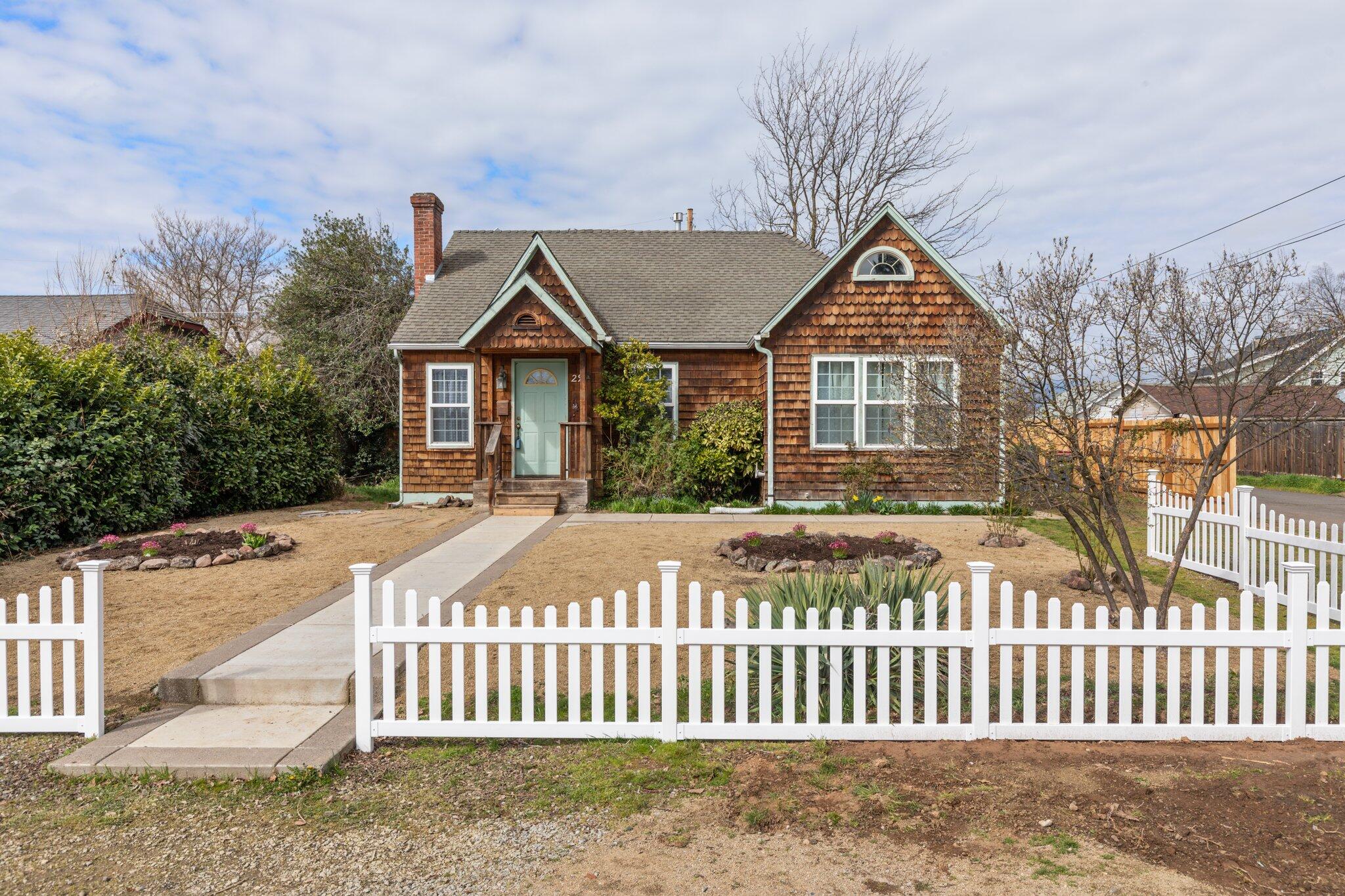 Open House Saturday! Charming 1920's cottage in a great location convenient to just about everything! The front yard is low maintenance with flowers just coming into bloom. The warm hardwood floors and stone fireplace greet you when you enter and high ceilings make it feel so welcoming.  Primary bedroom and the bath (with brand new toilet) are on the 1st floor privately tucked away down the hall from the rest of the house. The entire home has forced heating and air (installed 2017) and the seller just had solar vents installed in the 2 upstairs rooms (circulates air preventing warm spots) There is a surprising amount of natural light for an older home and the whole effect is bright and cheery.  The kitchen is situated in the back so you can look out over the large fenced back yard.  Garbage disposal is new and gas stove is included. With alley access, there may be opportunity to build an ADU and still have privacy for the main home