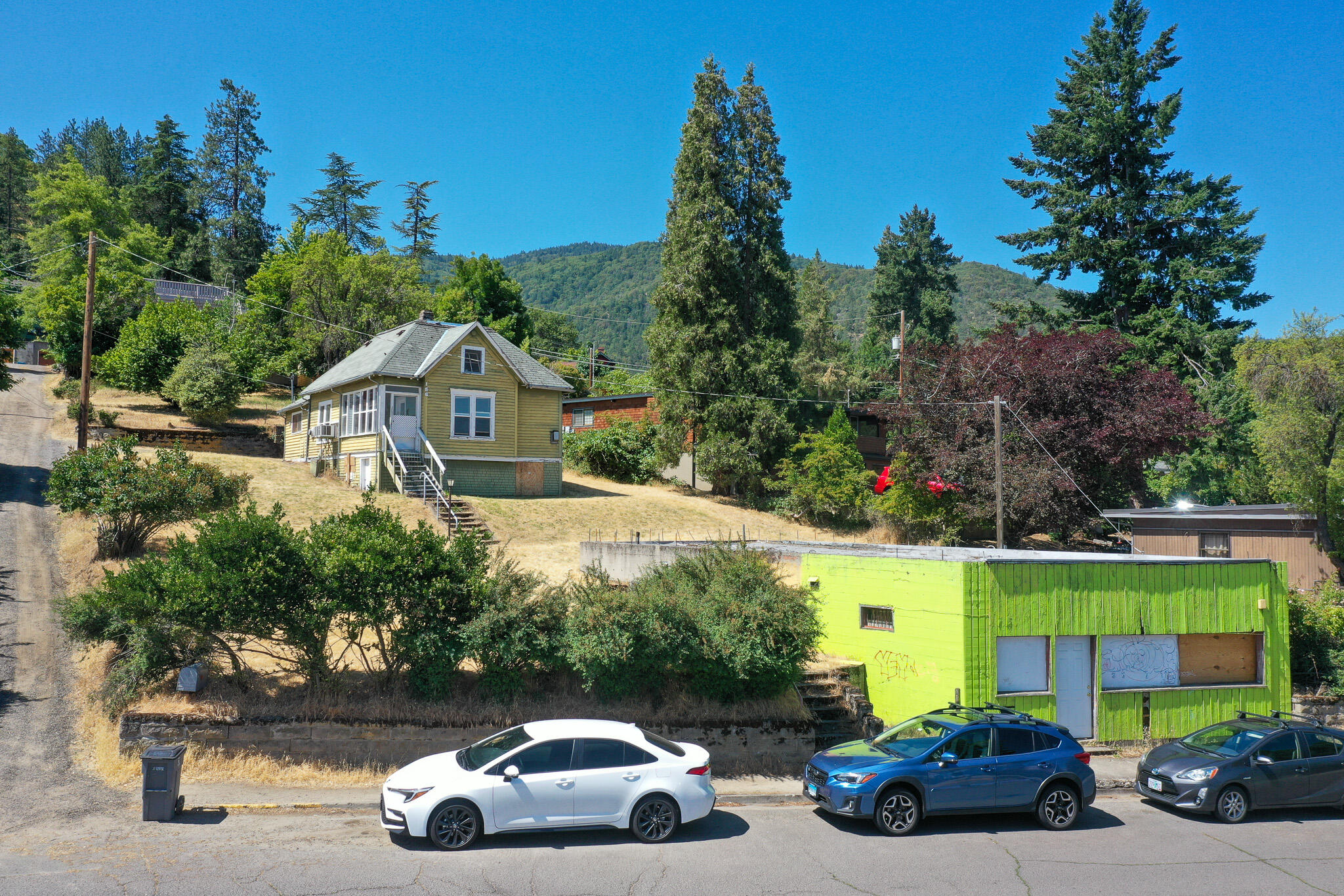 Location...location...location!!! This property is truly a rare find, blending residential and commercial opportunities. It is located in the Hargadine historic district just steps from the Oregon Shakespeare Festival and downtown Ashland. The lot is over 1/3 of an acre with expansive views of the mountains and Grizzly Peak in the distance and the historic Ashland Springs Hotel in the foreground. The turn of the century main house is 1450 sq ft with a large 950 sq ft basement.. The approximately 1100 sq ft commercial/retail space on Hargadine St. is a rare opportunity to blend a work and live opportunity on one lot. The lot could also accommodate additional homes or ADU. So renovate, build new or a combination of both! Check with the City for building options/density bonuses etc. This property, in the heart of downtown, is ready for your creativity and contractor to bring it back to life!
