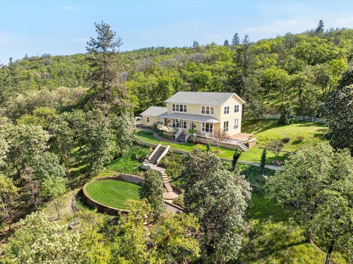 Take me home, country road. Perched above Griffin Creek Road with sweeping valley views, this custom contemporary farmhouse offers serene privacy, charm, and light-filled living. Nestled on a peaceful hillside off Mel Lowe Lane, it features expansive windows, a wide front porch, and a side deck ideal for sunrise coffee or sunset wine. The kitchen with island and gas stove flows into the dining area and living room, where French doors and transom windows add elegance and light. A main-level bedroom doubles as a cozy in-home theater. Also on the main floor: a full bath, utility room, and pantry for added flexibility. Upstairs, the spacious primary suite boasts a jetted tub, walk-in closet, bonus closet, and incredible views. Two oversized guest rooms—one with a custom Murphy bed—plus another full bath round out the upper level. Thoughtful details shine throughout: custom cabinetry, pine floors, and timeless touches. A truly unique home in an unforgettable setting.