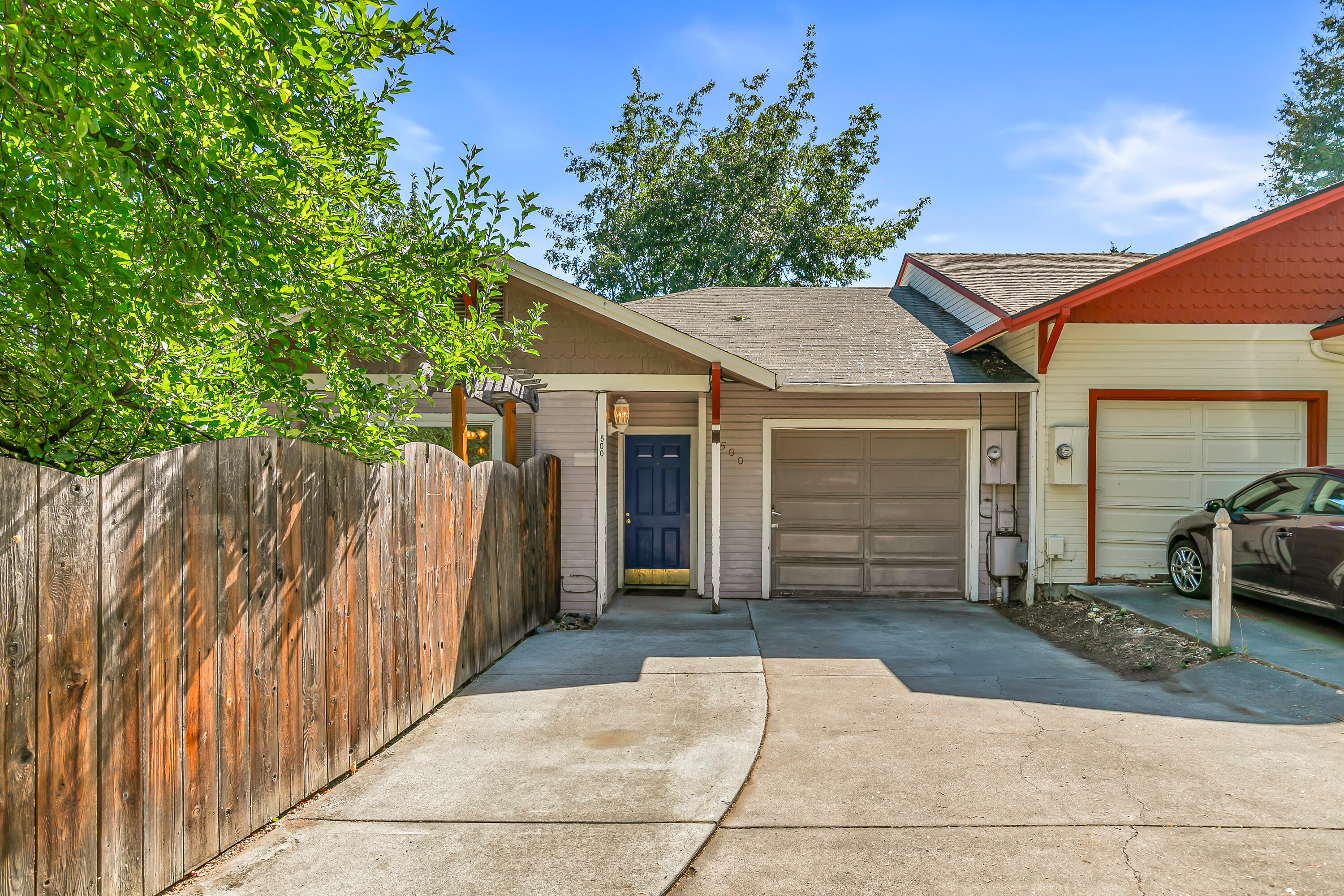 Very private single-level cottage tucked away on a flag lot with mature trees near Ashland Creek Park, within four minutes of Ashland's downtown plaza! Living room with ceiling fan and adjacent dining area with French doors to fully-fenced private backyard with concrete patio, sunny gardening areas, mature plantings, and fruit trees. Kitchen with concrete counters, double sink, stainless refrigerator, four-burner electric cooktop with hood, built-in microwave and oven. Primary bedroom with ceiling fan, closet, and full ensuite bathroom with pedestal sink and shower. Second bedroom with ceiling fan and walk-in closet. Full guest bathroom with pedestal sink and tub shower. Finished bonus room or office, plus a converted garage storage area. Small association covers landscaping and maintenance of common area with grass lawn and guest parking spaces. Rented for $1,850 per month from 2021 through 2025. Property shall be sold ''As-Is'' in present condition. Inquire for details!