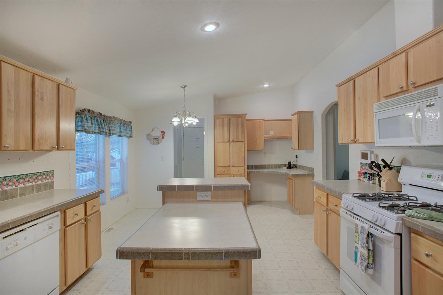 This gem of a house will absolutely surprise you. It is situated on a very tranquil wooded parcel that backs up to BLM on the North, yet minutes to town. The well-maintained, gated, gravel drive winds gently up to a large paved parking area with 2-car garage and RV hookups. This home does not have the feel of a MFG home. It has a lovely wood fireplace, vaulted ceilings, very large kitchen with upscale cabinetry and nice appliances. Laundry and pantry are conveniently located. Master bedroom has a large walk-in closet and spacious bath. There are several areas located on the property that take advantage of the great setting including a beautiful enclosed front porch, covered back patio, and Koi pond. Make this your own special retreat.